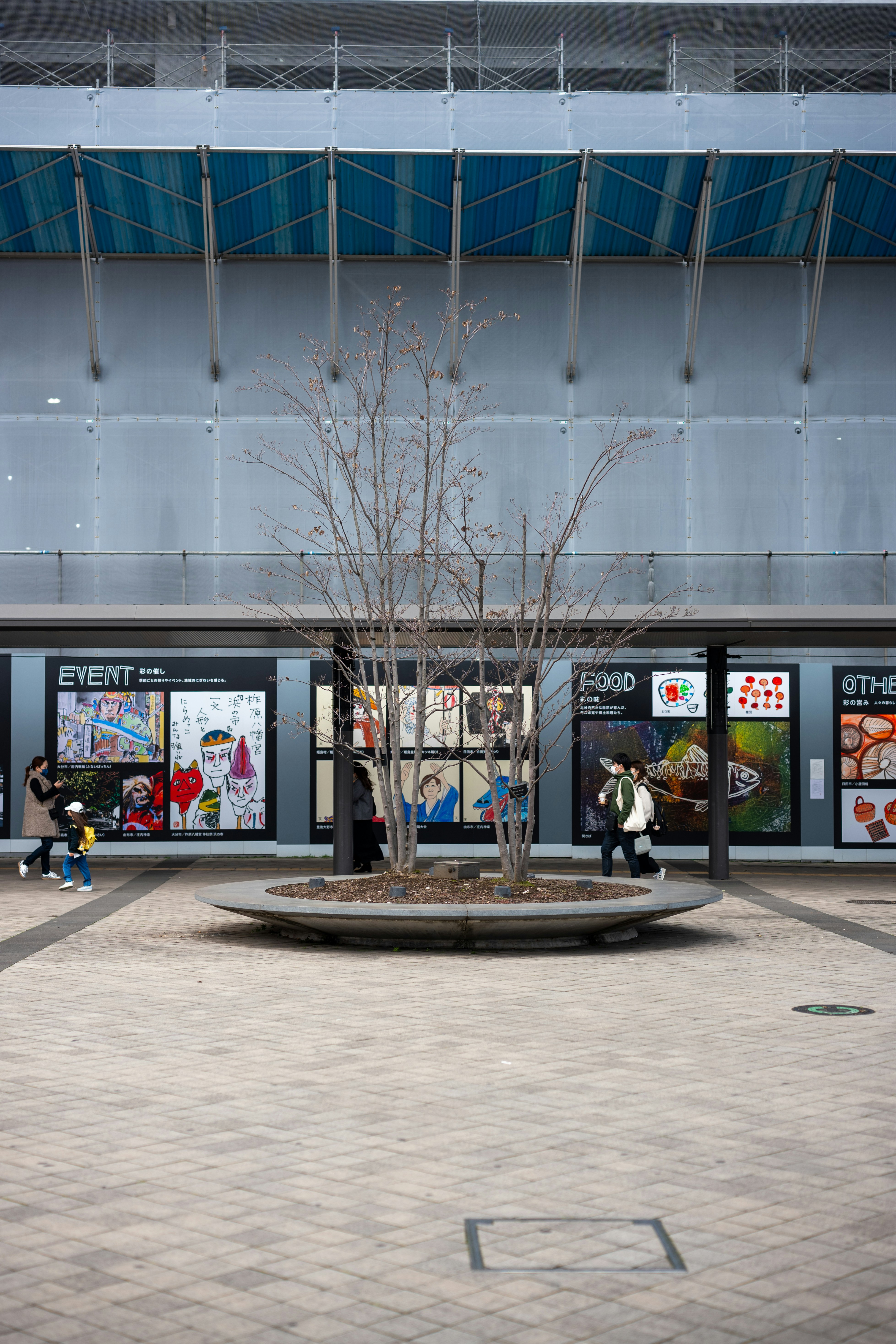 Die Leute gehen an Ausstellungen auf einem modernen städtischen Platz vorbei.