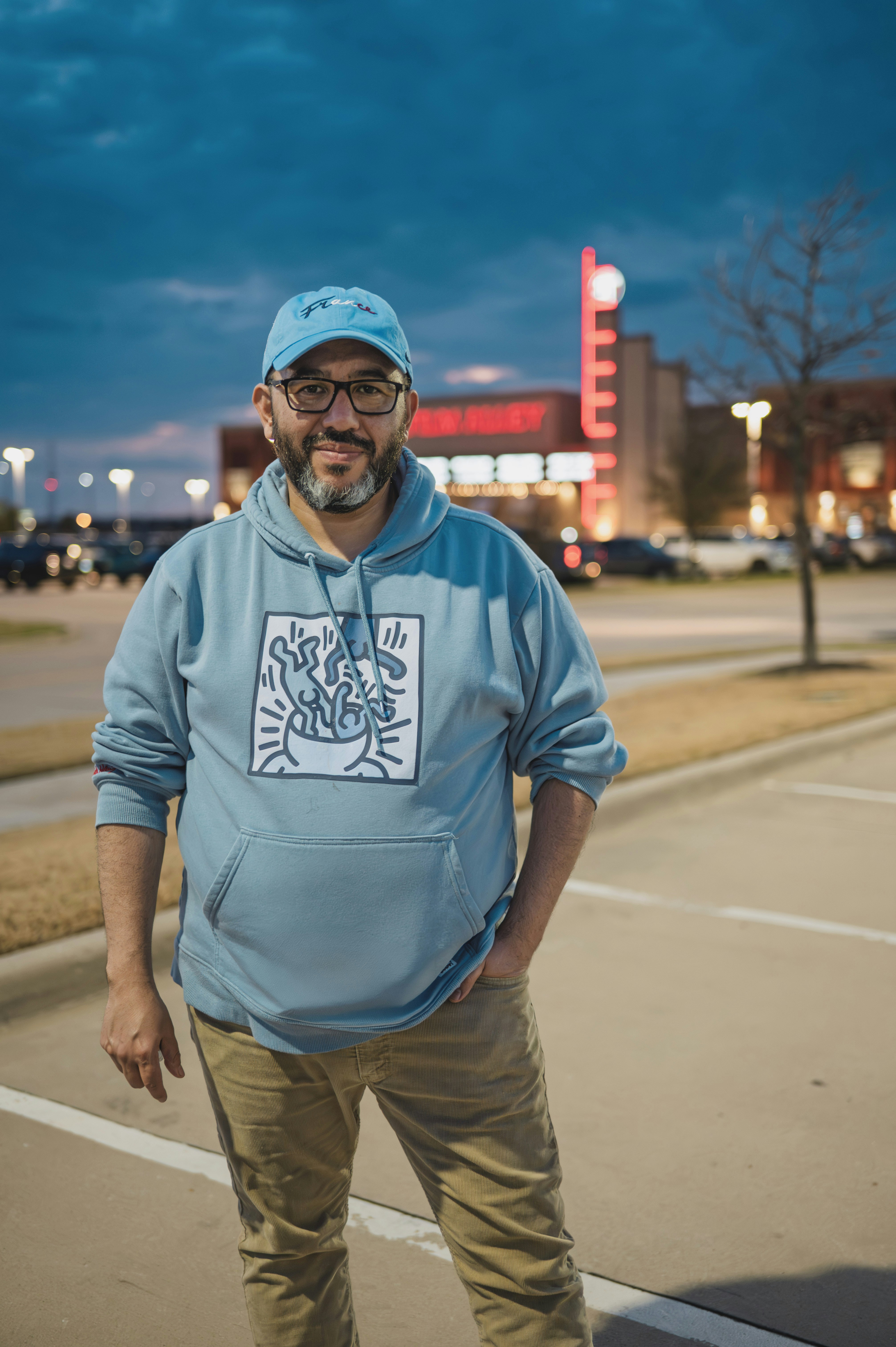 파란색 후드티와 모자를 쓴 남자가 밖에 있어.