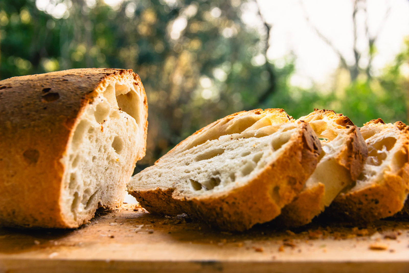 Thick slices of crusty rye and seed bread on a wooden board