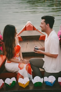 Man proposes to woman in a boat with lanterns.