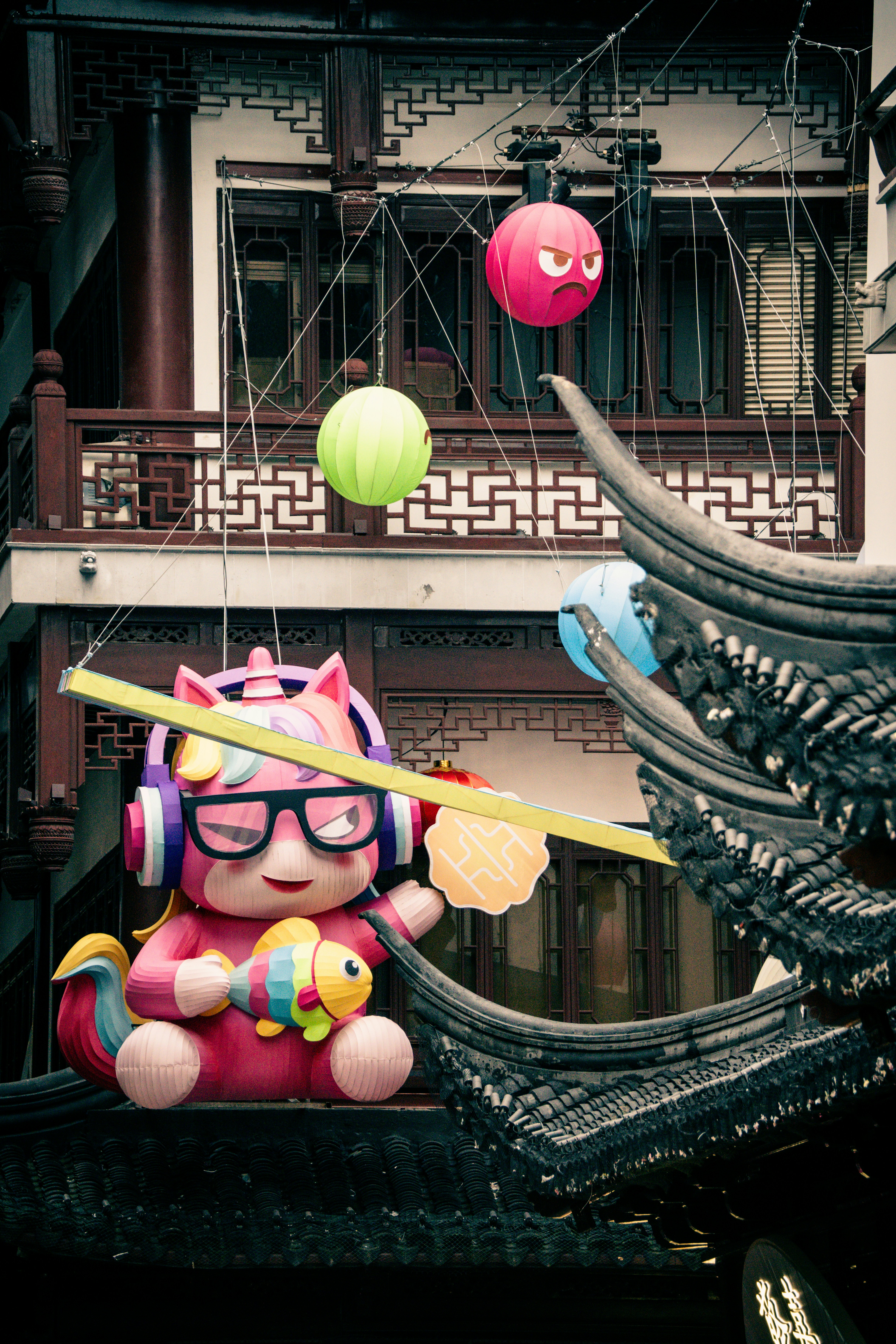 Pink cartoon character with headphones and glasses holds a fish.