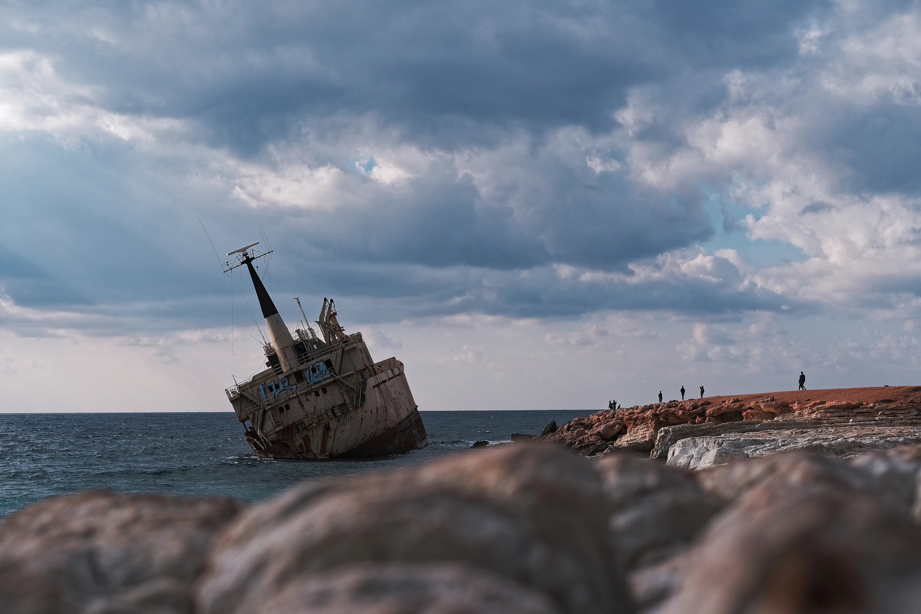 The rusted hull of the Edro III lying grounded on the rocks off the coast near Paphos under a heavy sky