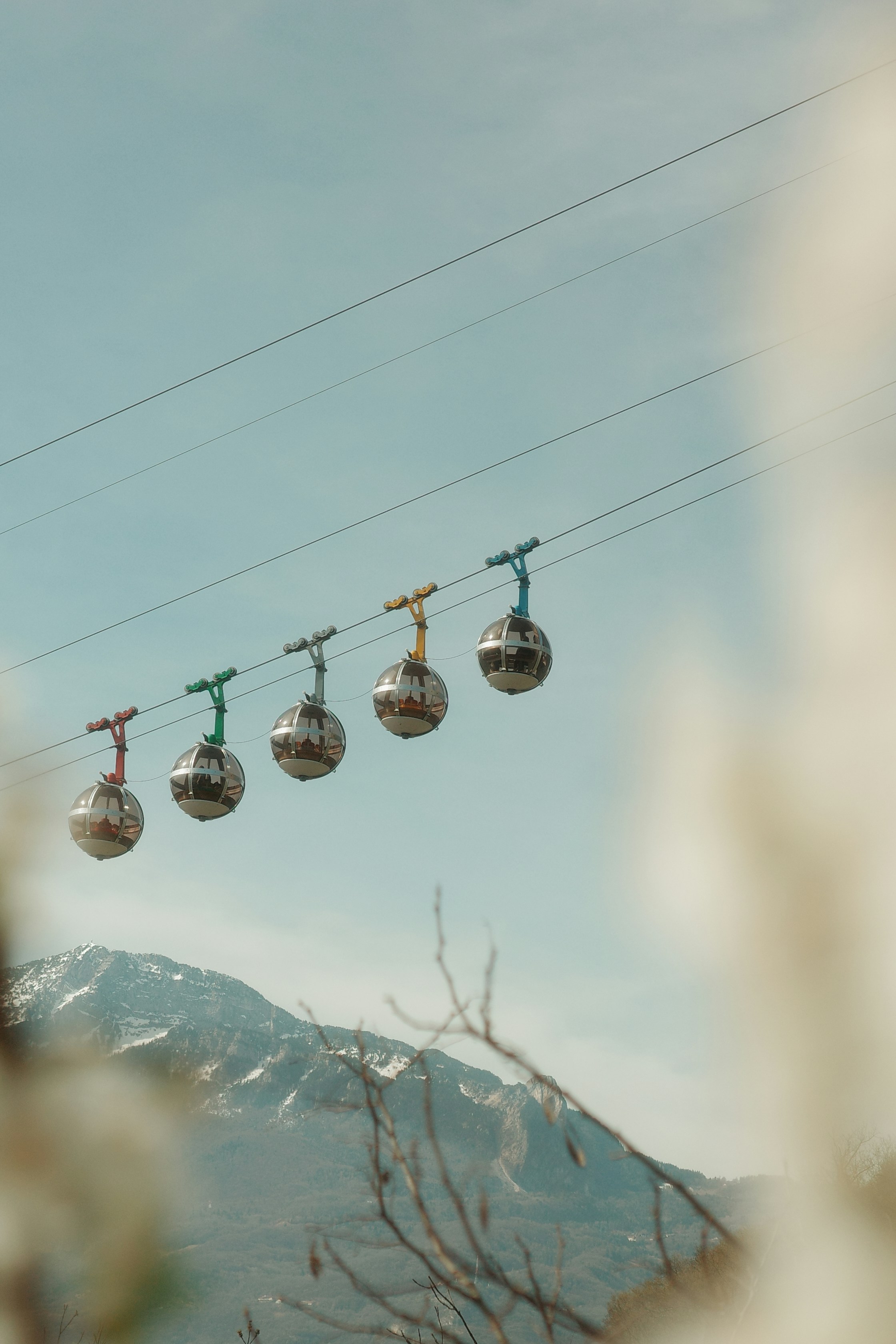 Several colorful cable cars ascend a mountain slope