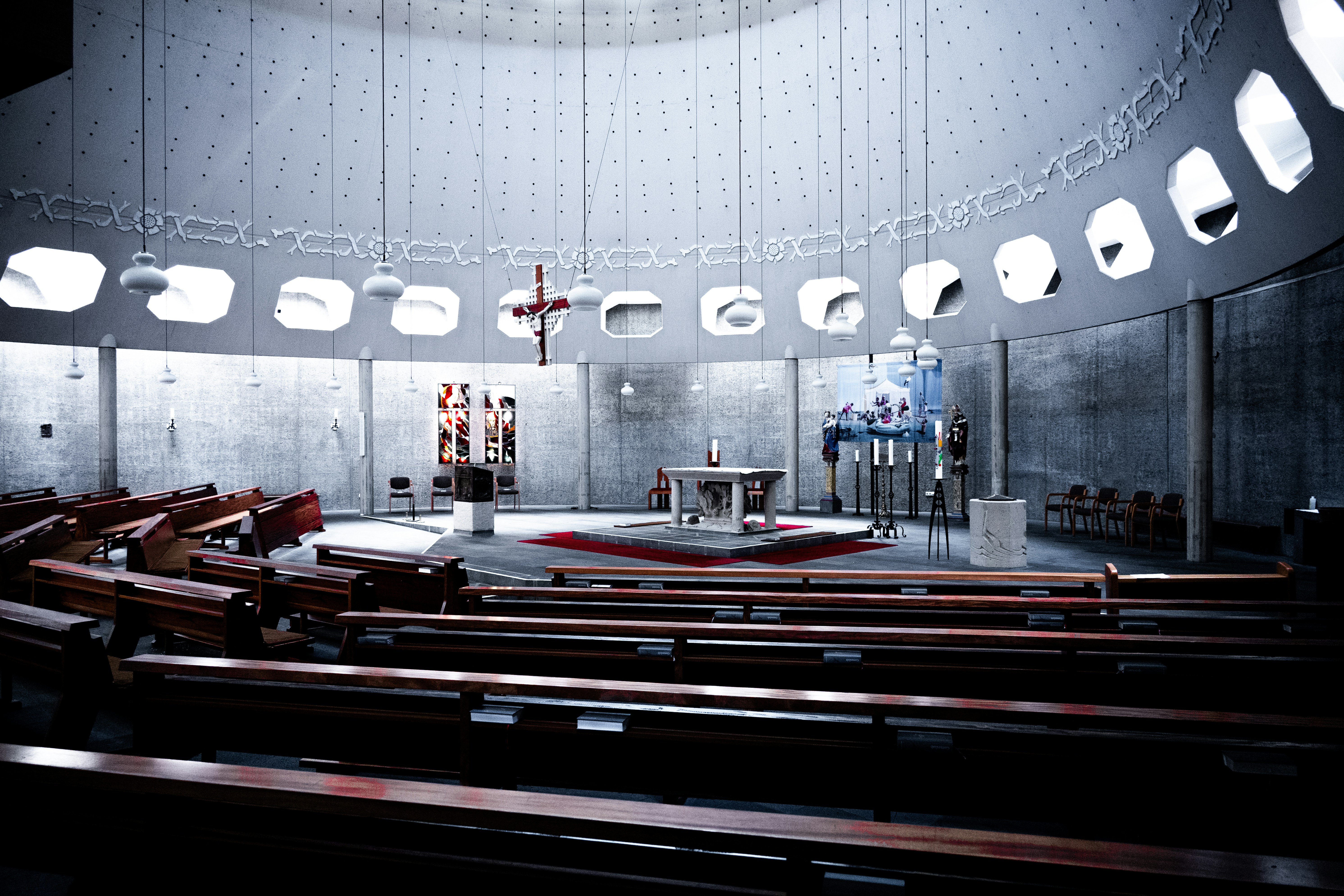 Interior moderno da igreja com bancos e altar.