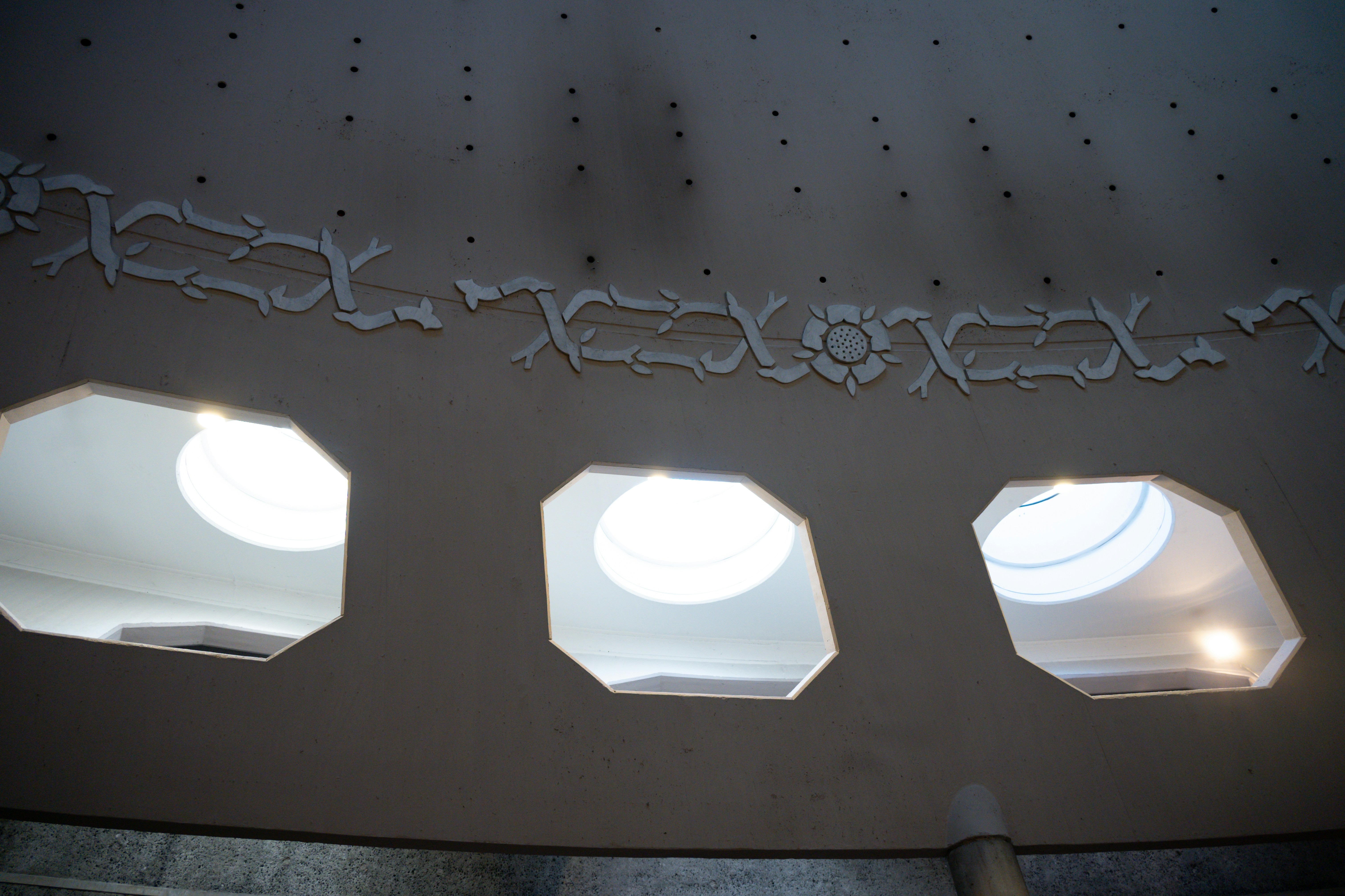 Três claraboias octogonais iluminam um teto texturizado