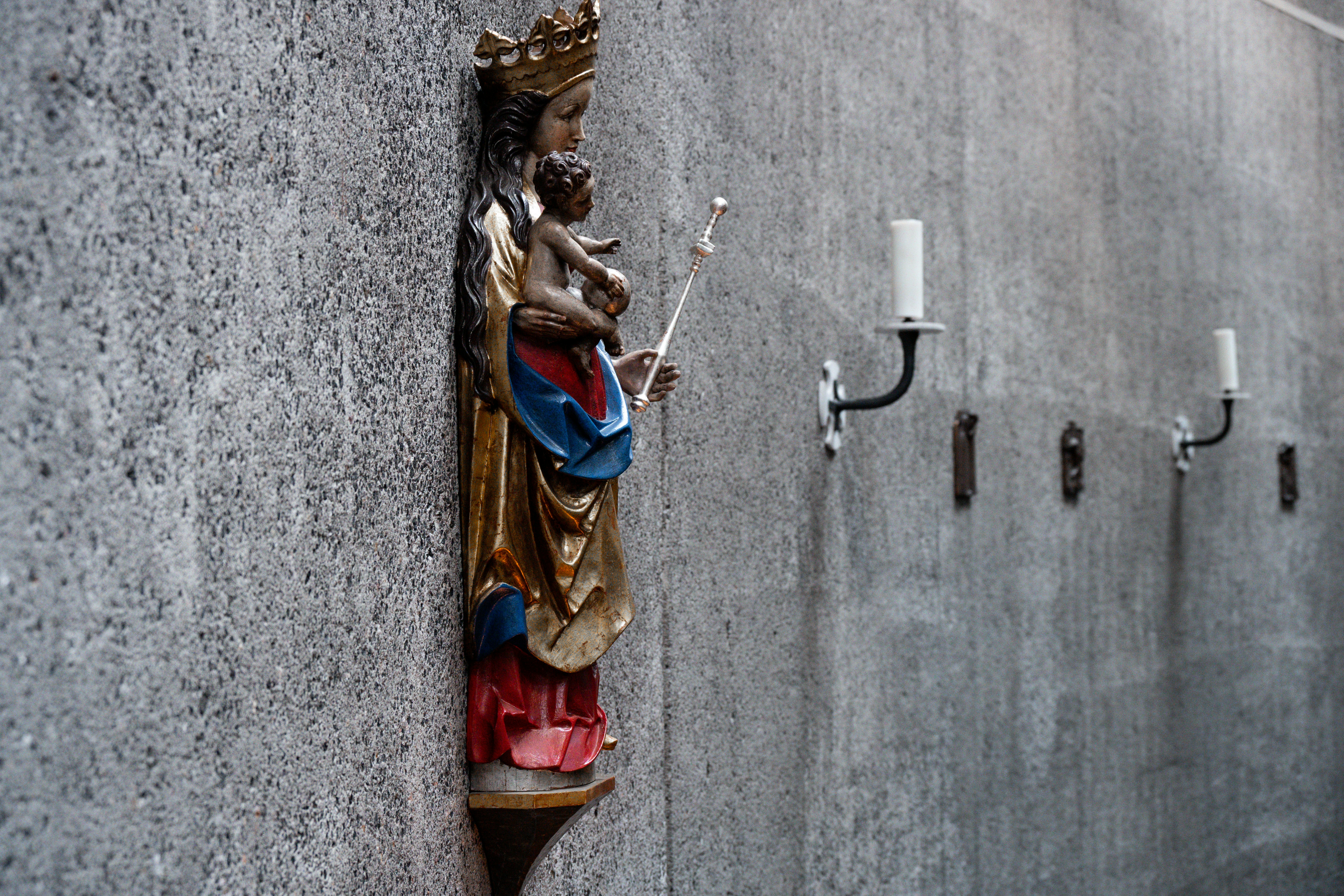 Una estatua religiosa de María con el Niño en una pared.