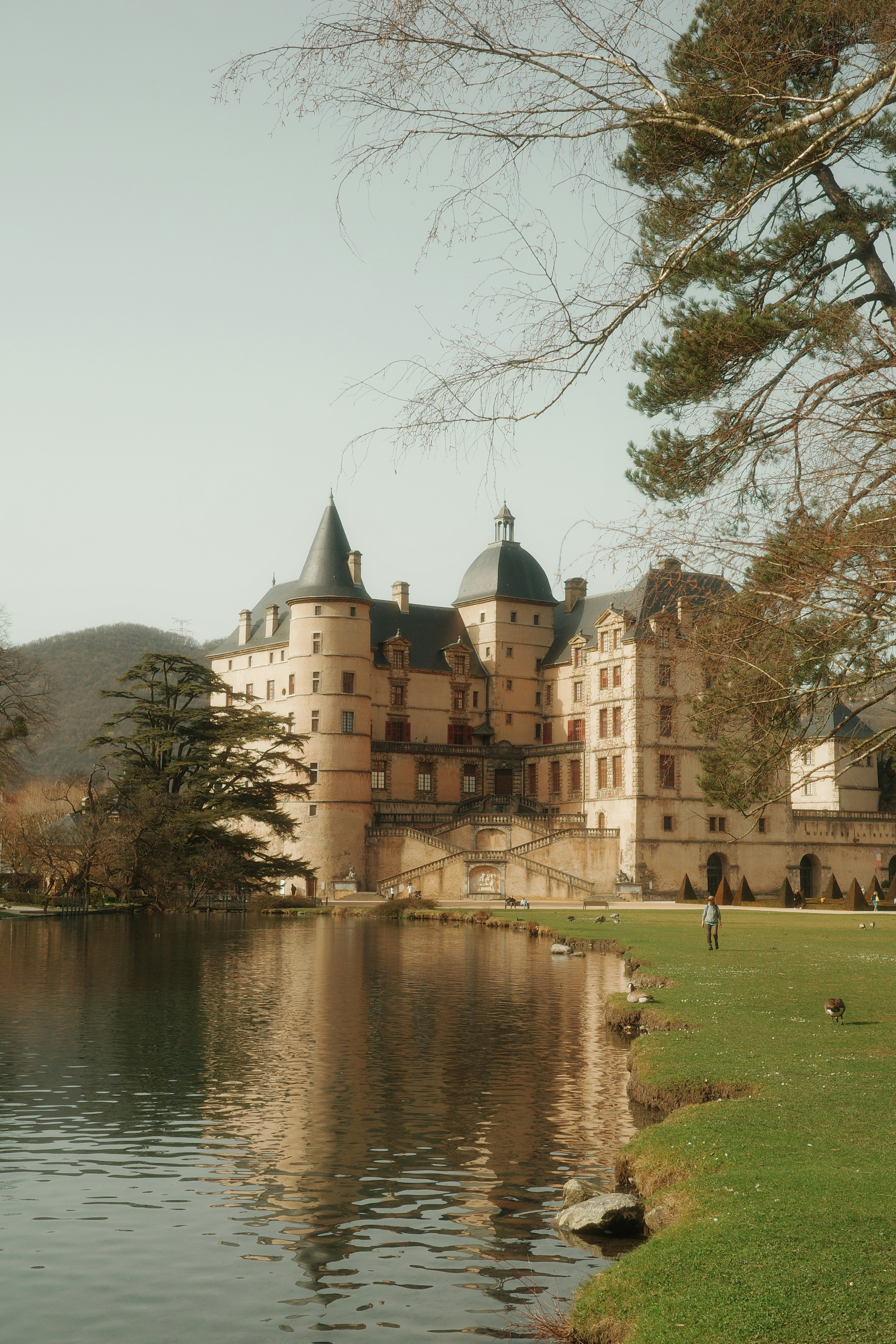 A grand castle sits beside a reflective lake