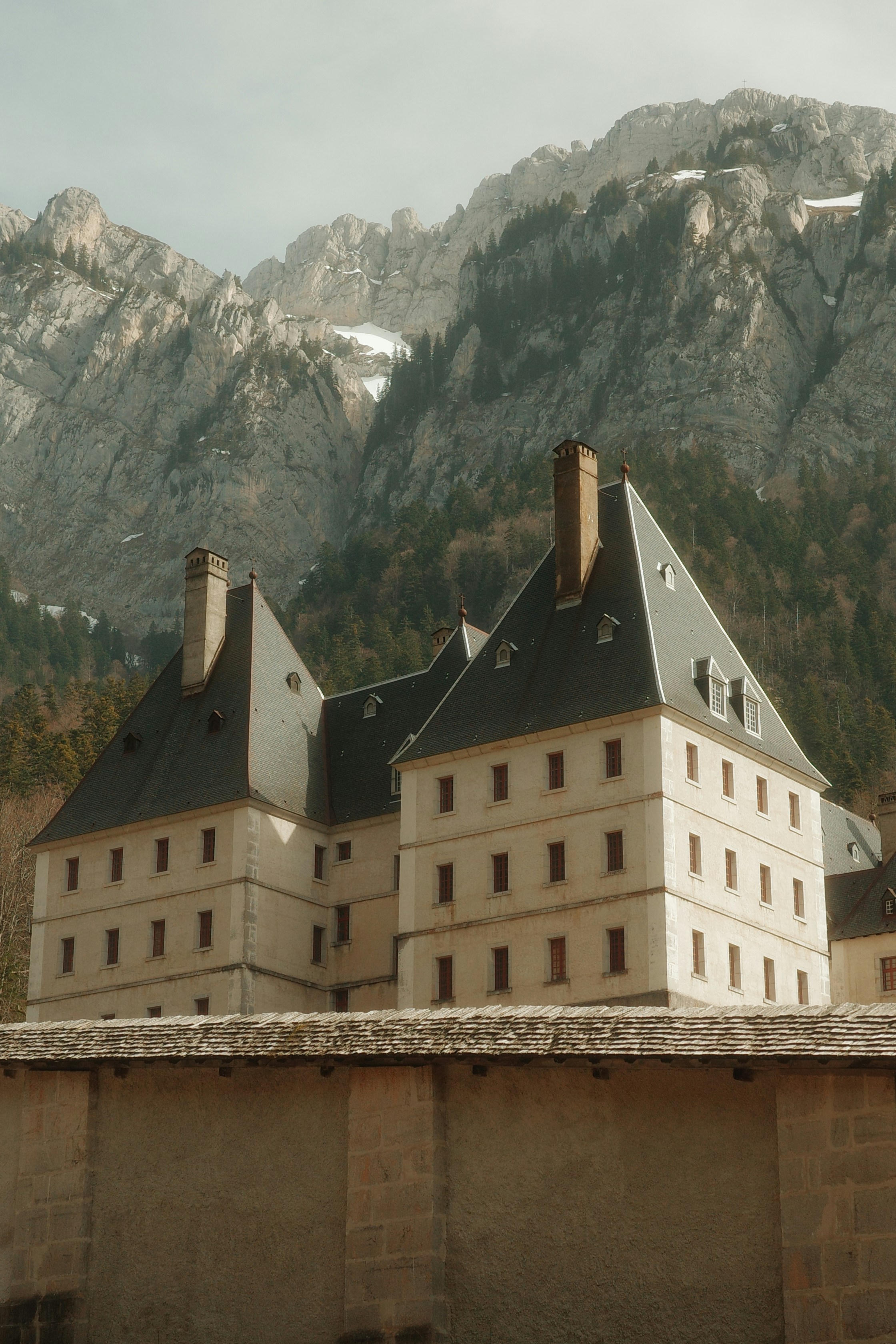 Large building with steep roofs against mountains