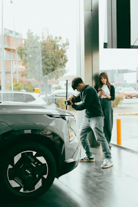 Man photographs car while woman watches