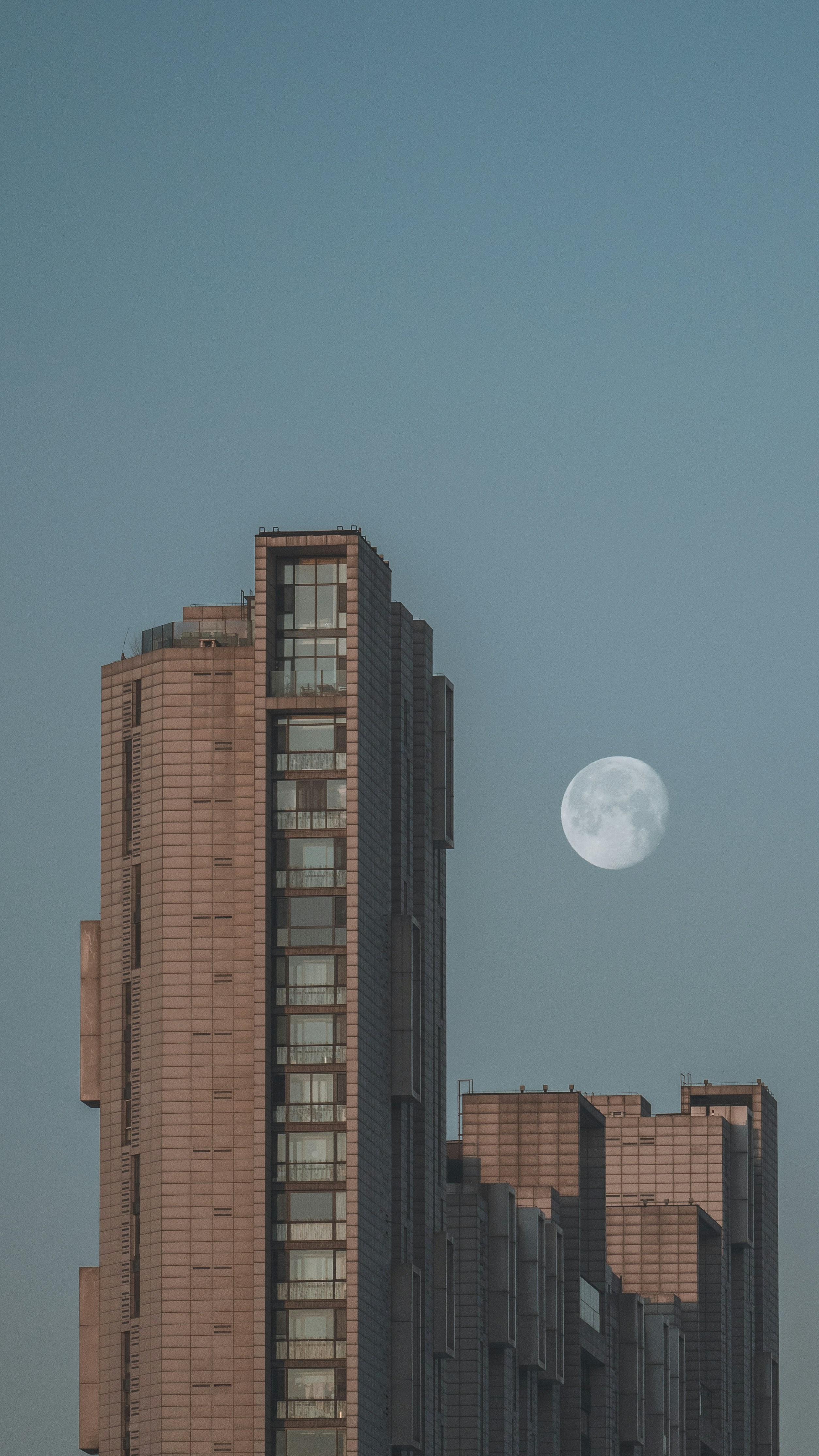 Moderner Wolkenkratzer mit Vollmond am klaren Himmel