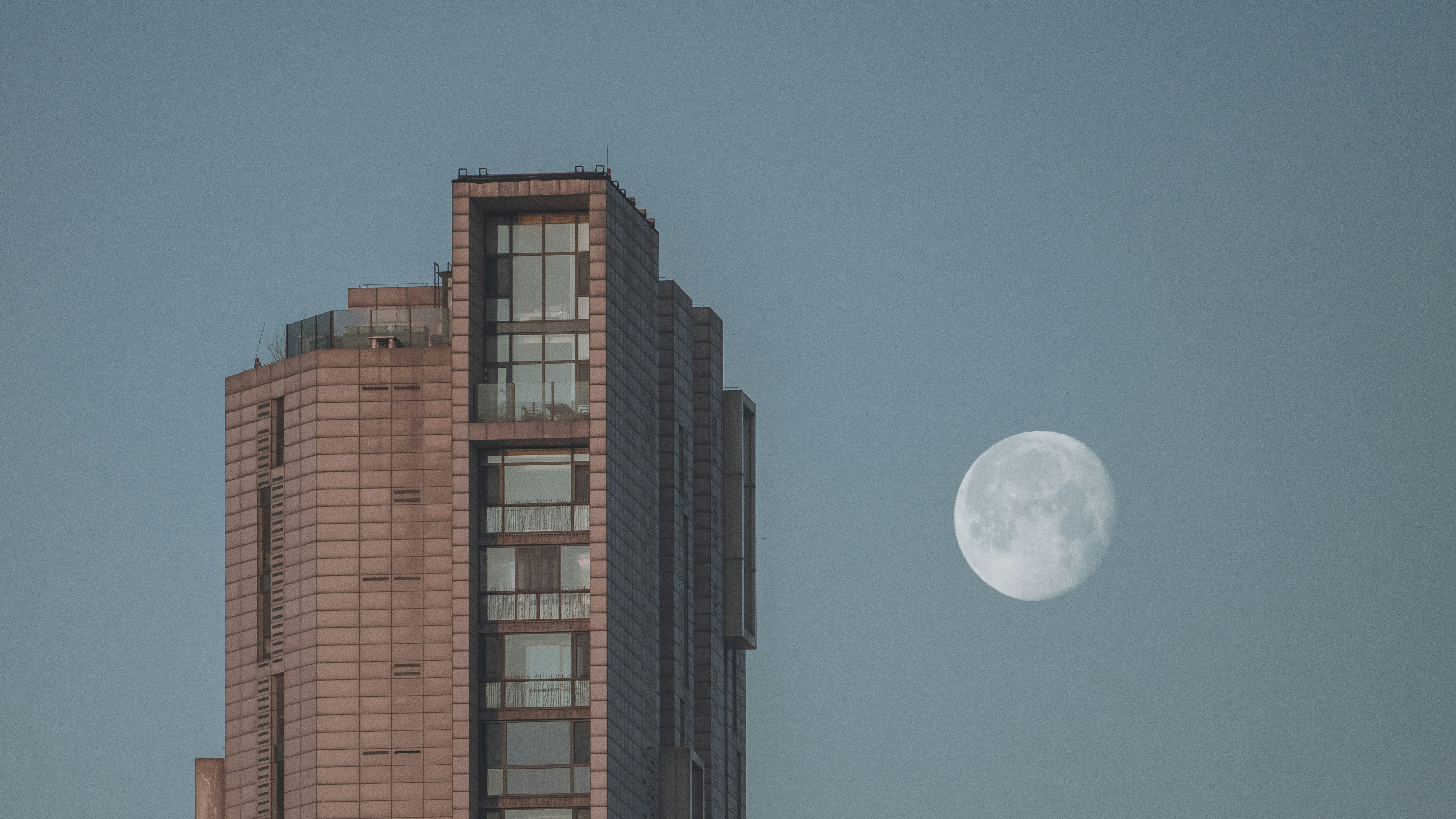 Ein hohes Gebäude mit dem Mond am Himmel