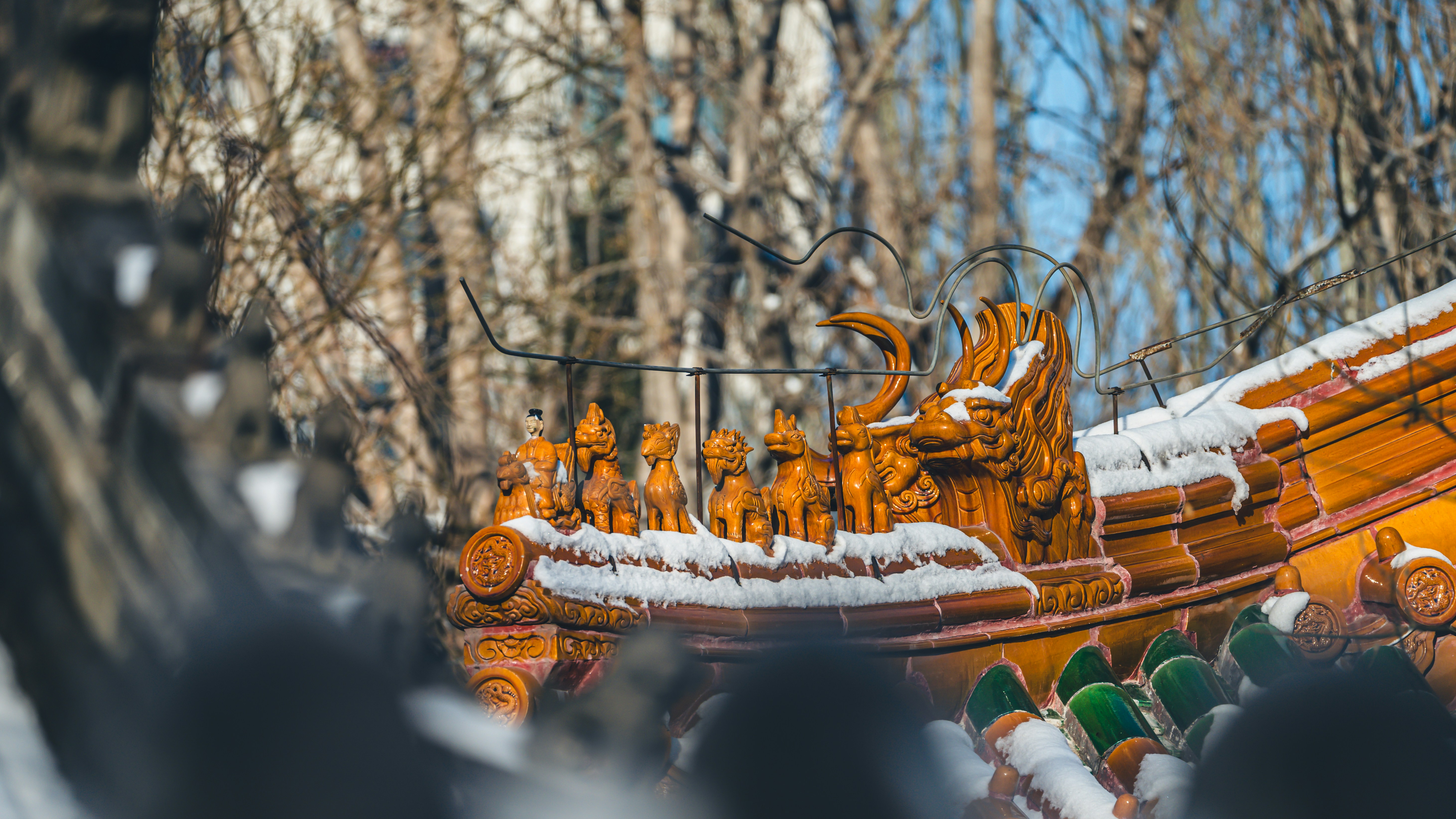 Schneebedecktes verziertes Dach mit Drachenskulptur im Winter