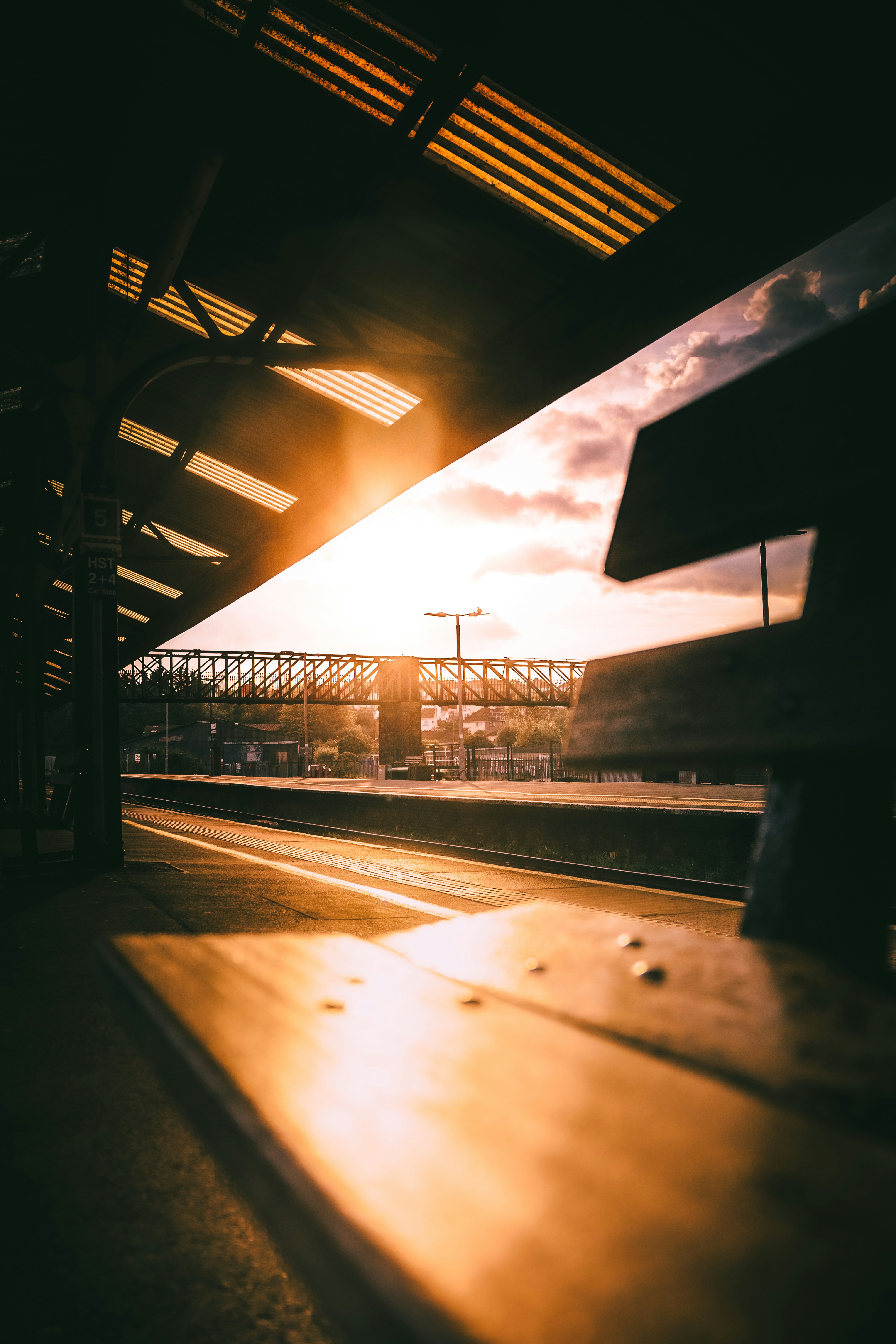 Golden sunset illuminates an empty train station platform.