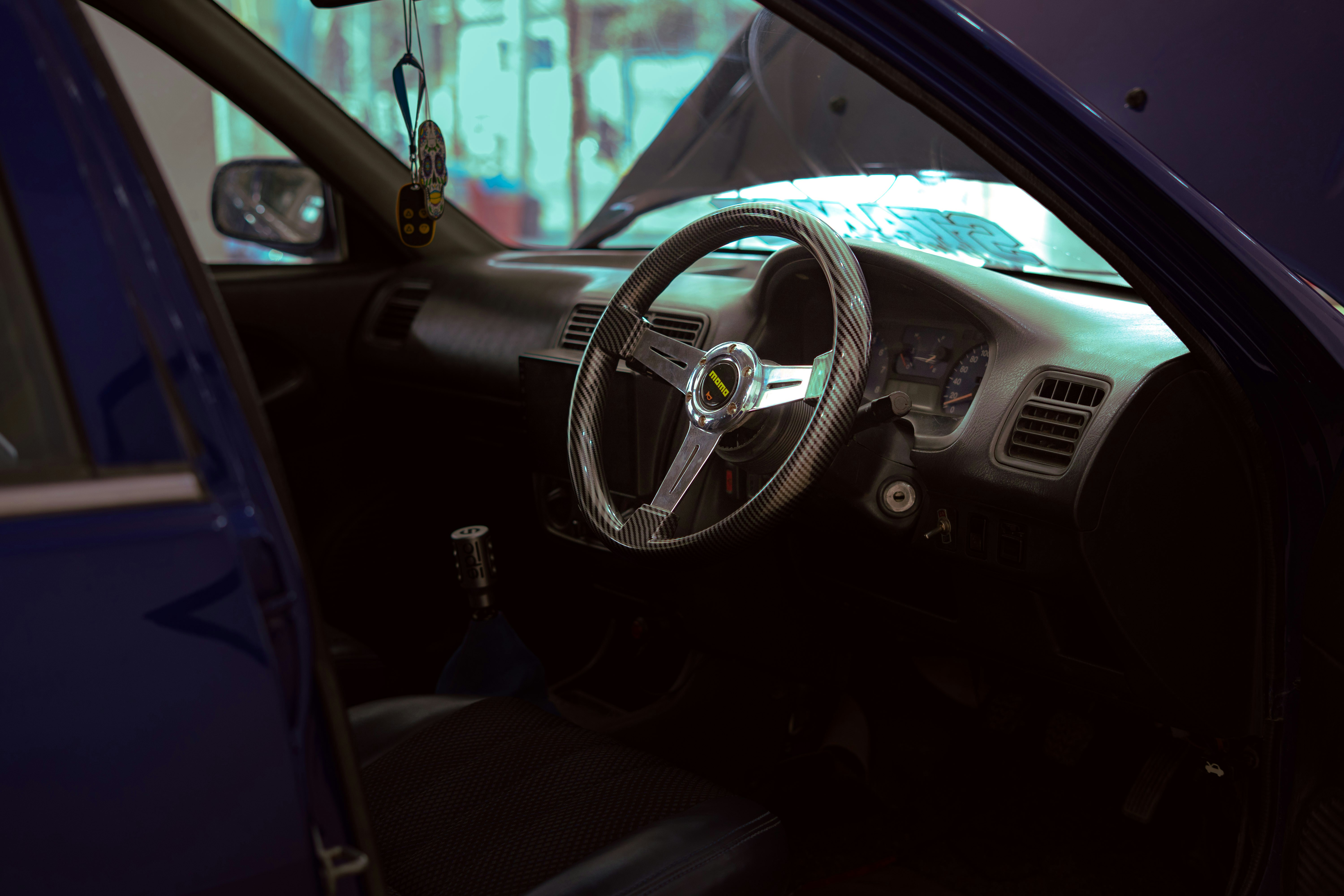Interior of a blue car with aftermarket steering wheel