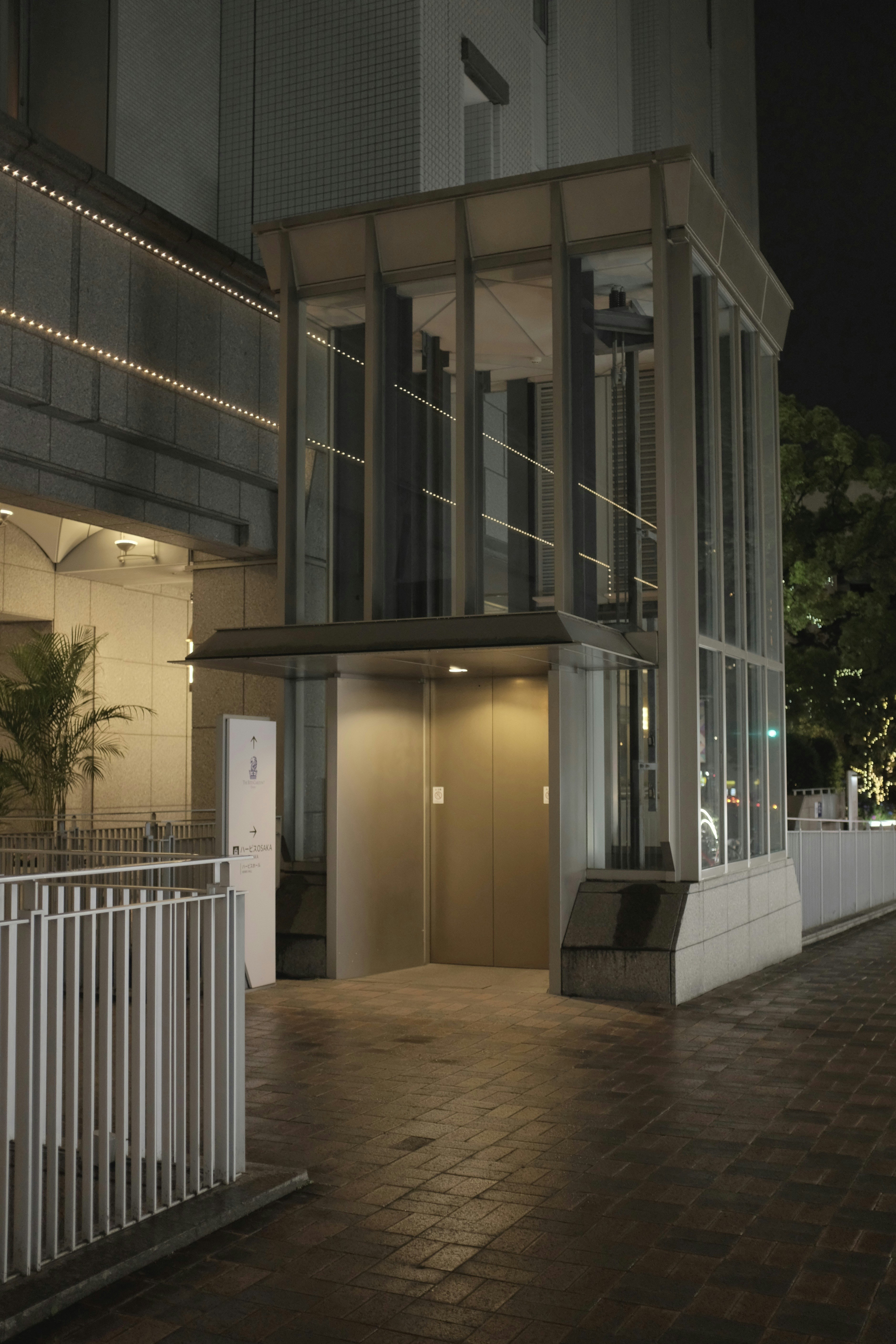 Pintu masuk kaca modern ke bangunan di malam hari