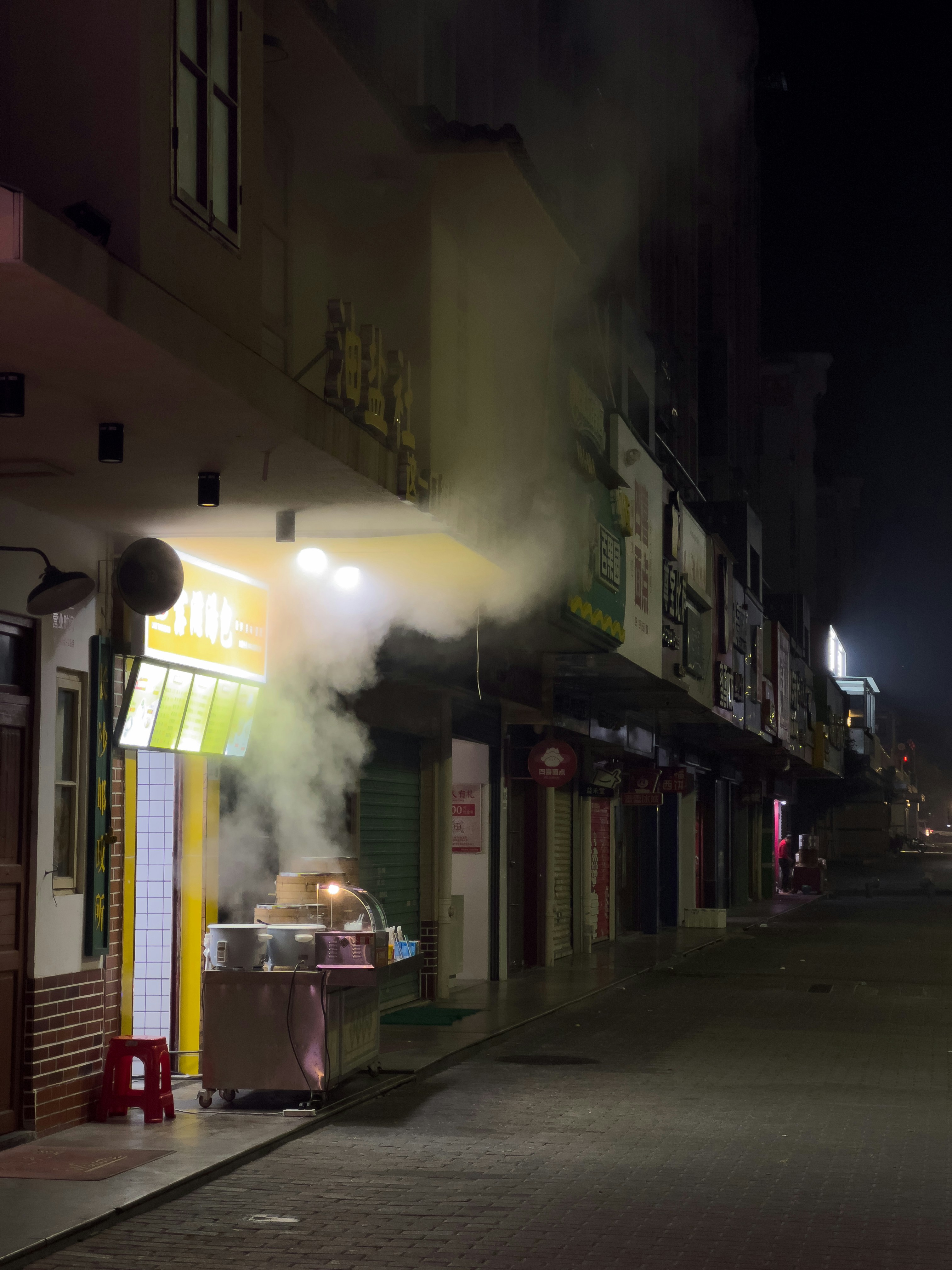 Nachts steigt Rauch aus einem Ladenlokal auf.