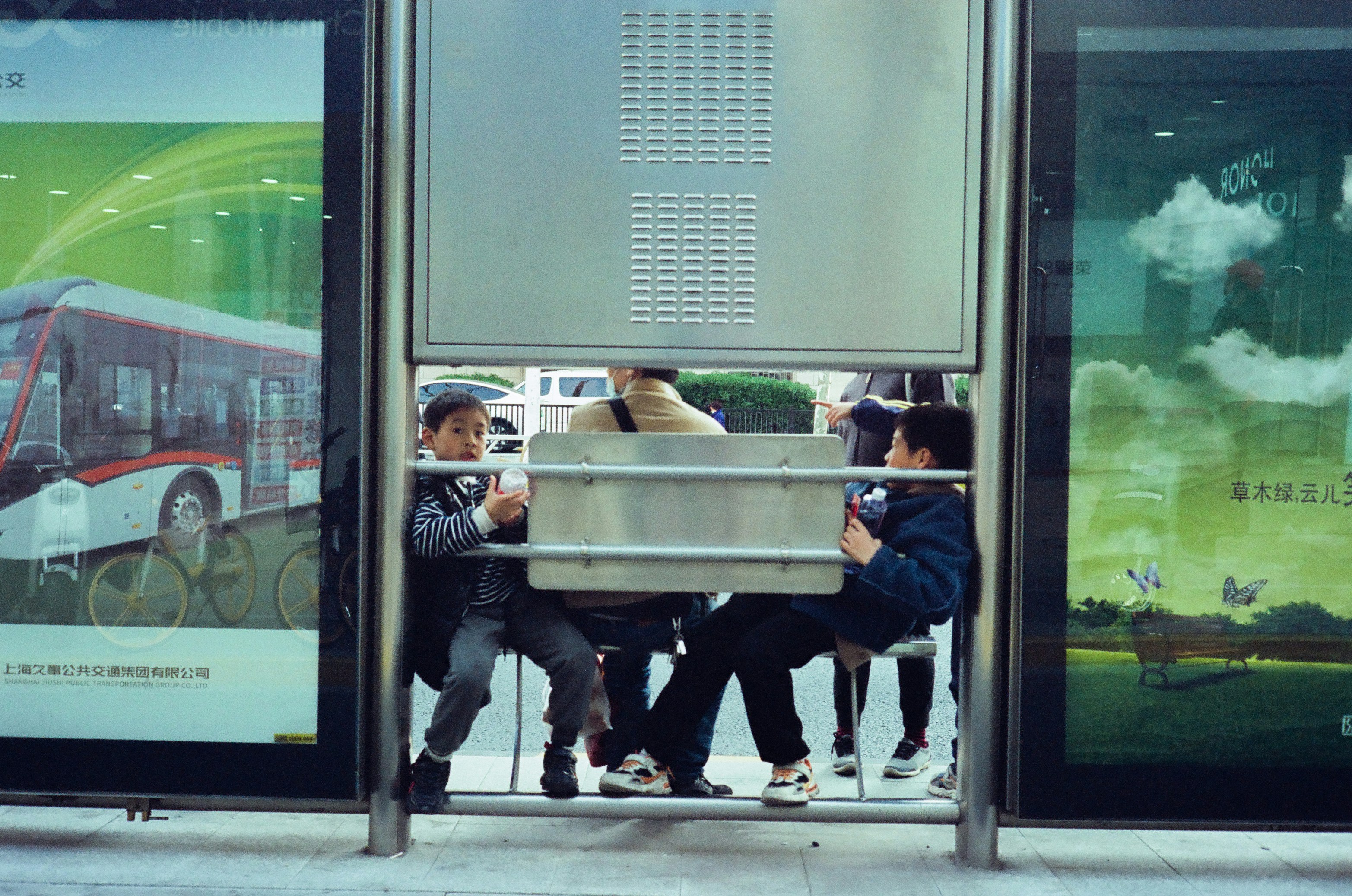 Die Menschen versammelten sich an einer Bushaltestelle mit Werbung