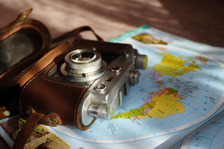Vintage camera rests on a world map.