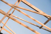 Wooden roof beams against a clear blue sky