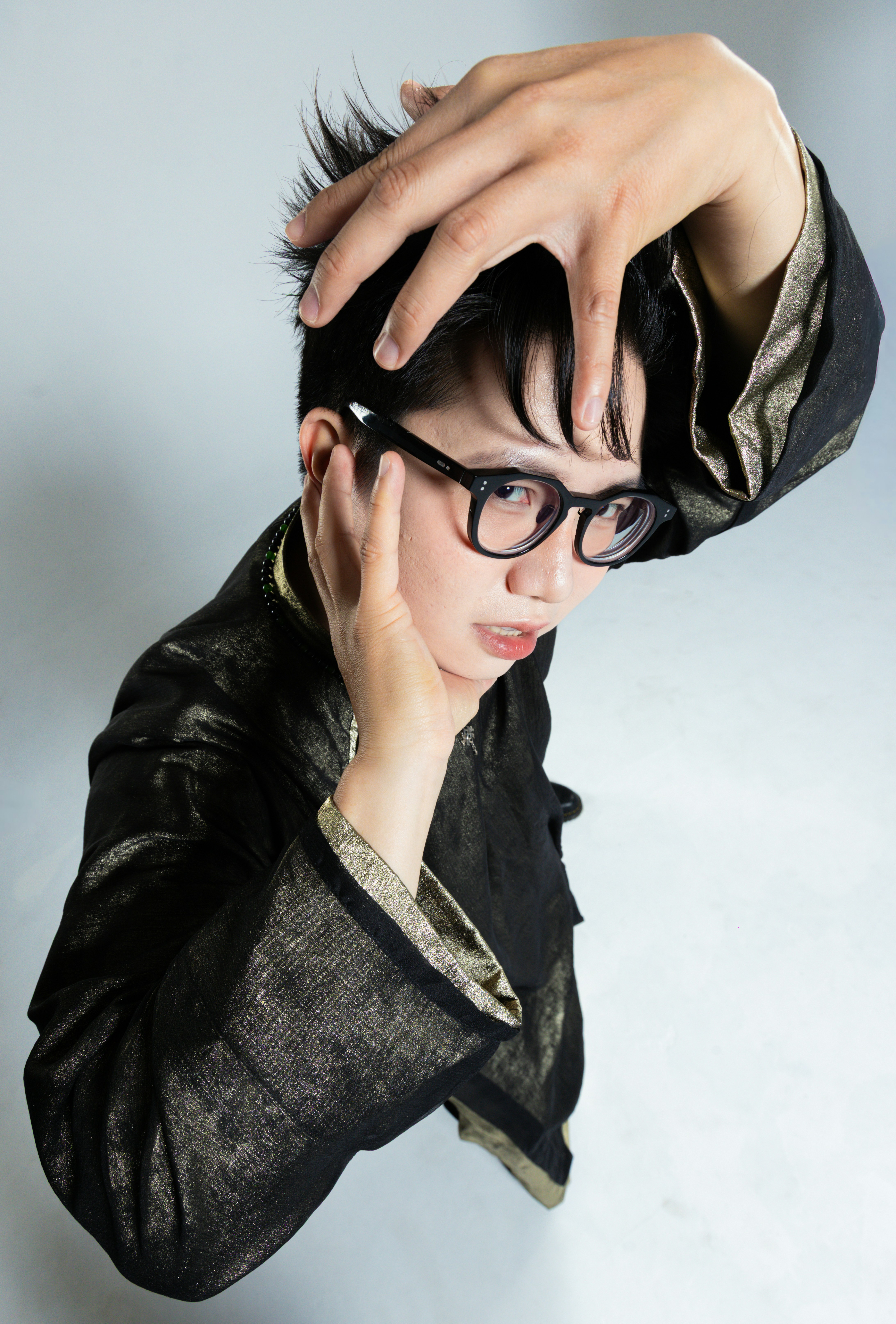 Young person with glasses and black jacket