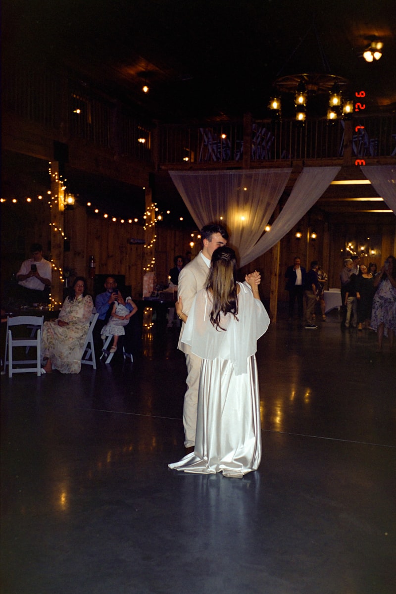 Grand Barn interior at night with string lights above long reception tables