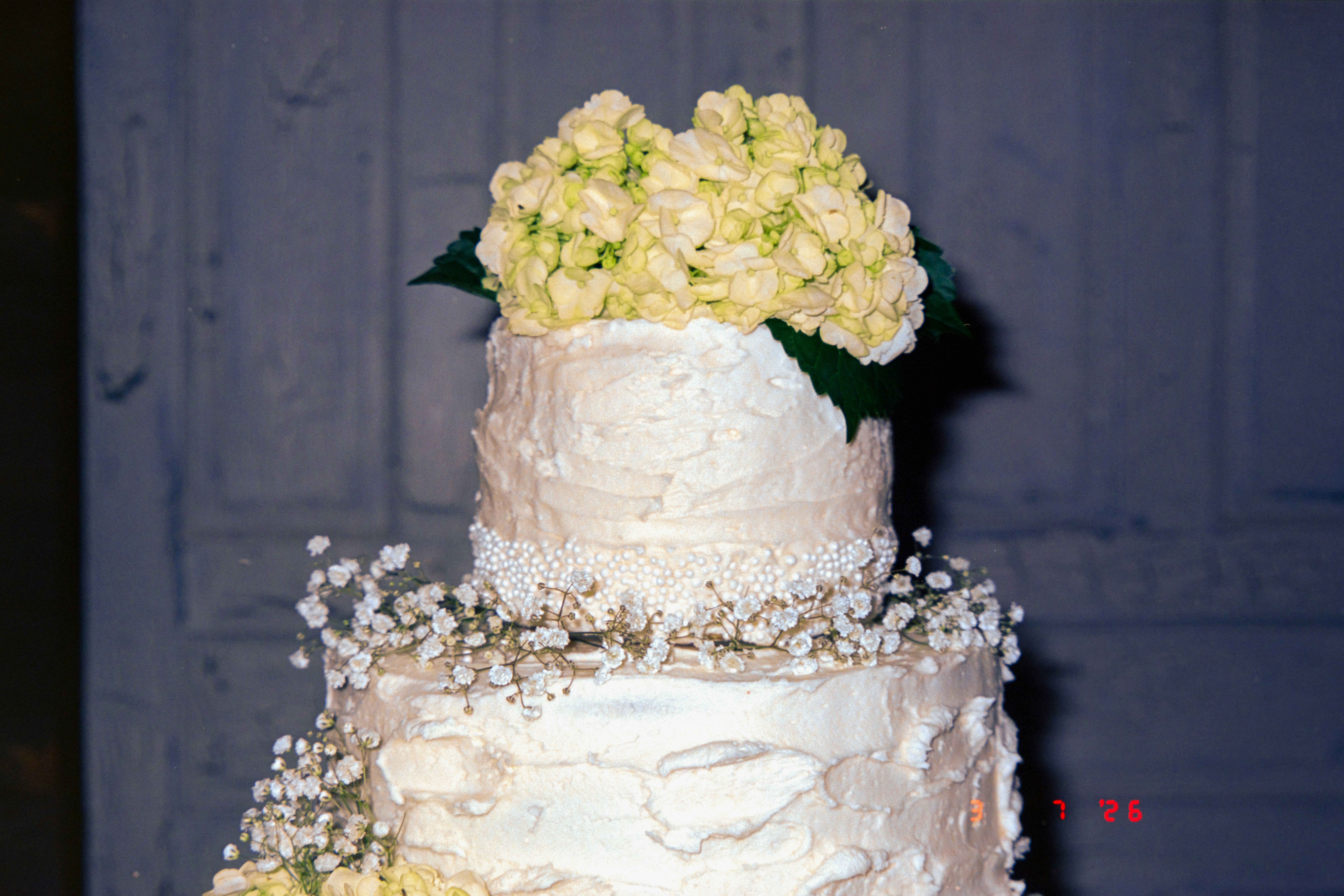 Ivory wedding tier cake with sugar flowers and pistachio rose layers
