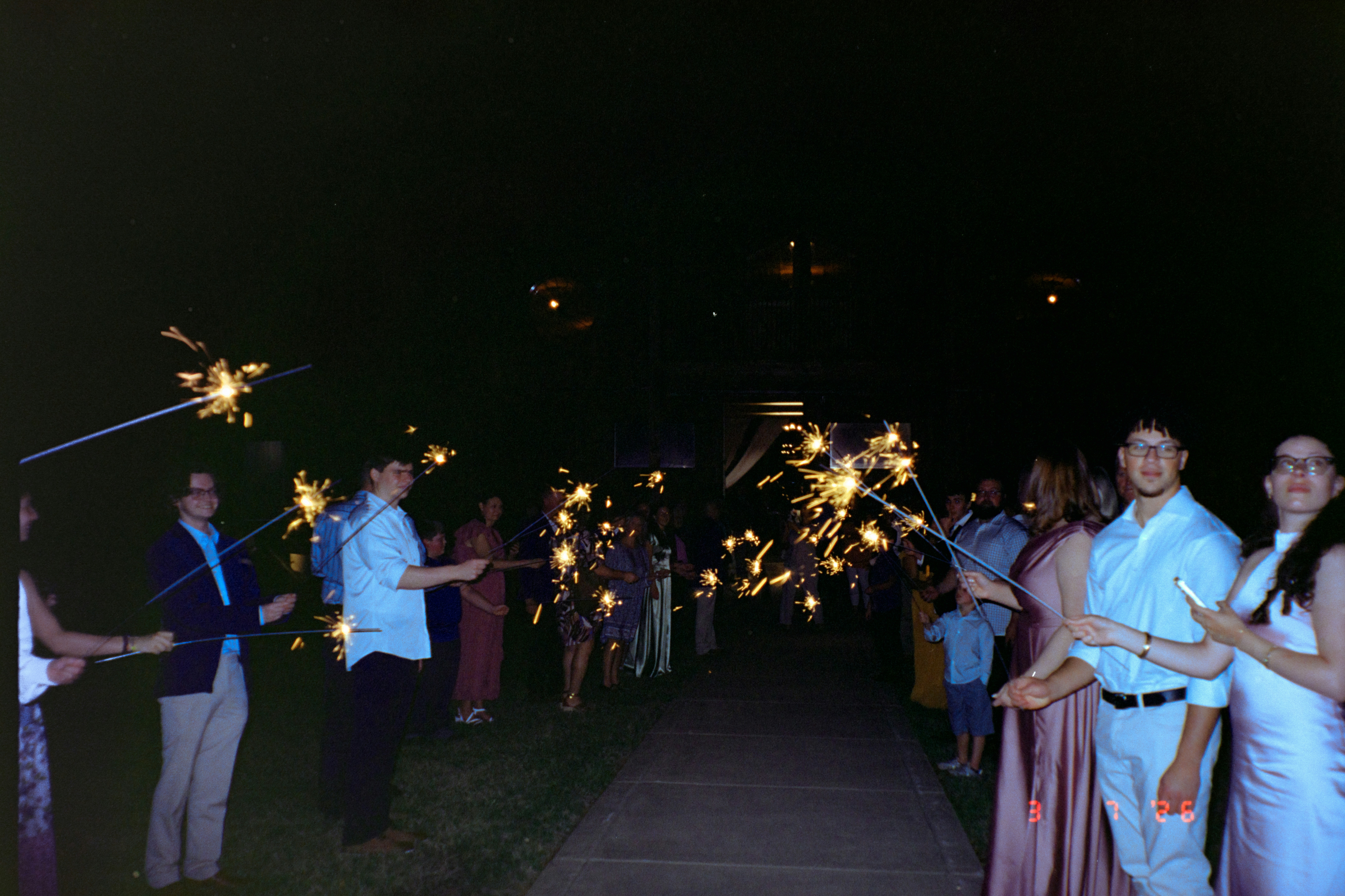 Pessoas segurando fogos de artilharia à noite