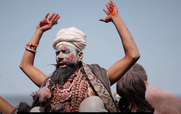 Man with painted face and arms raised