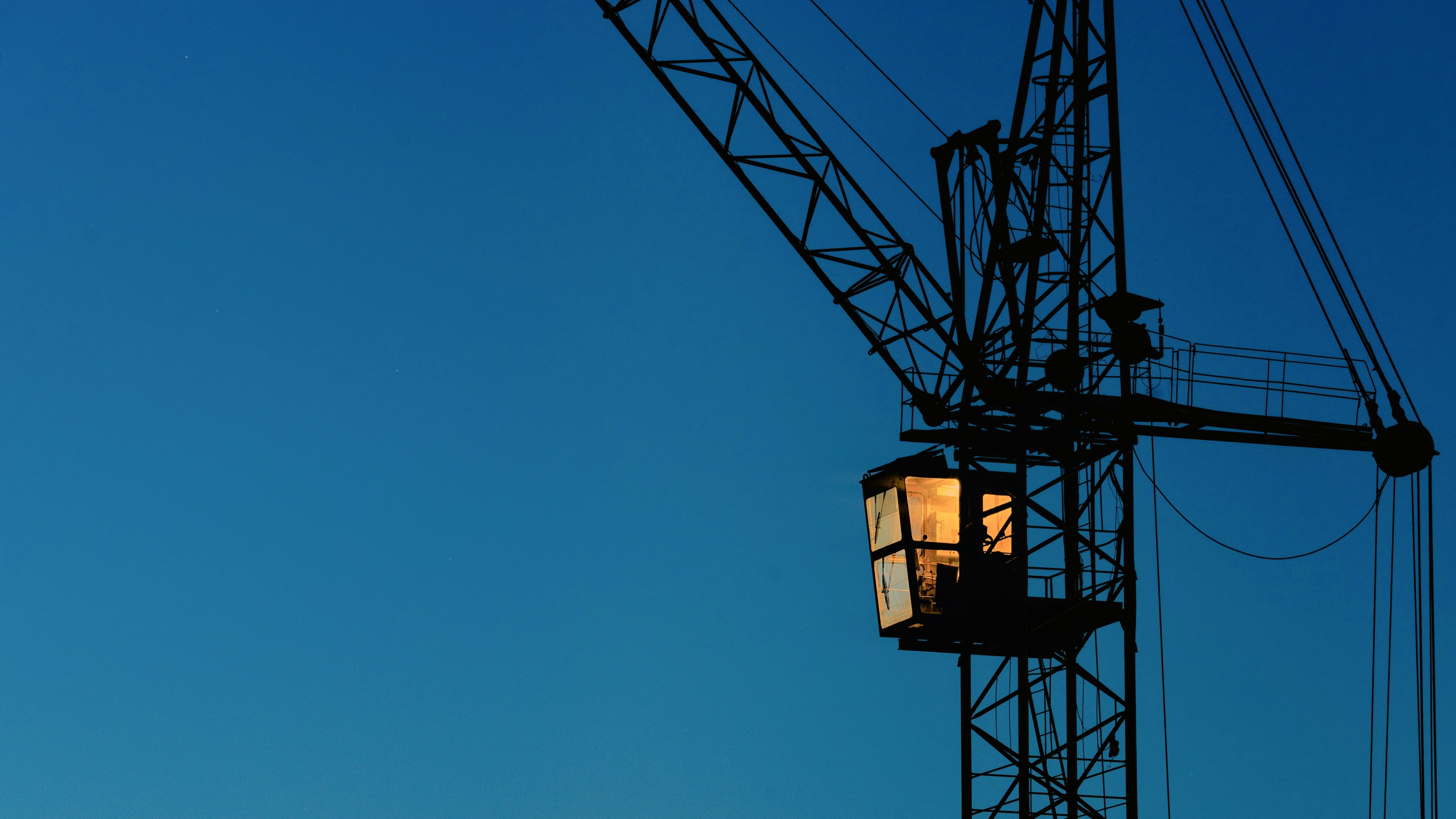 A construction crane against a clear blue sky.