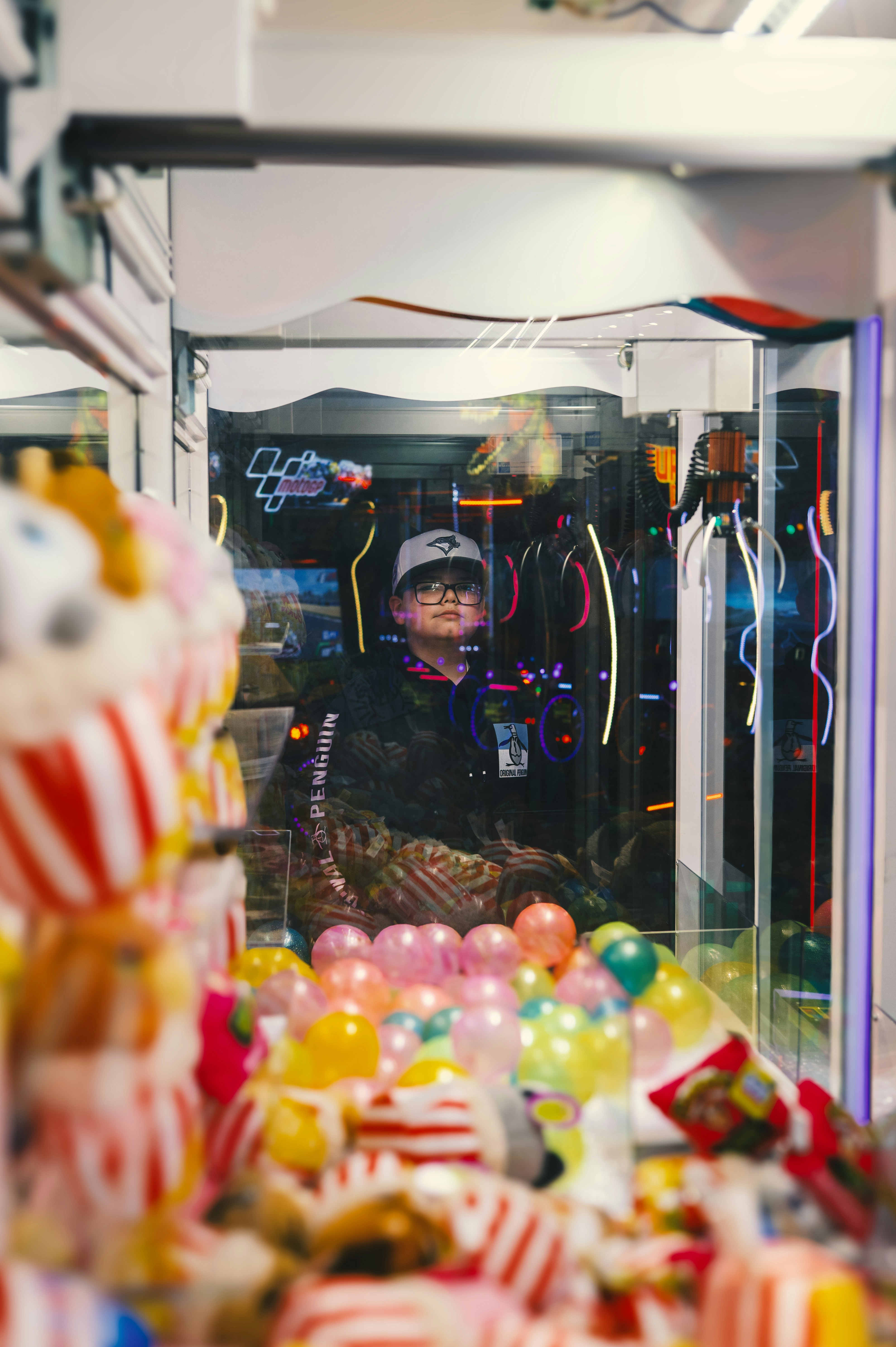 장난감이 가득한 발톱 기계를 들여다보는 소년.