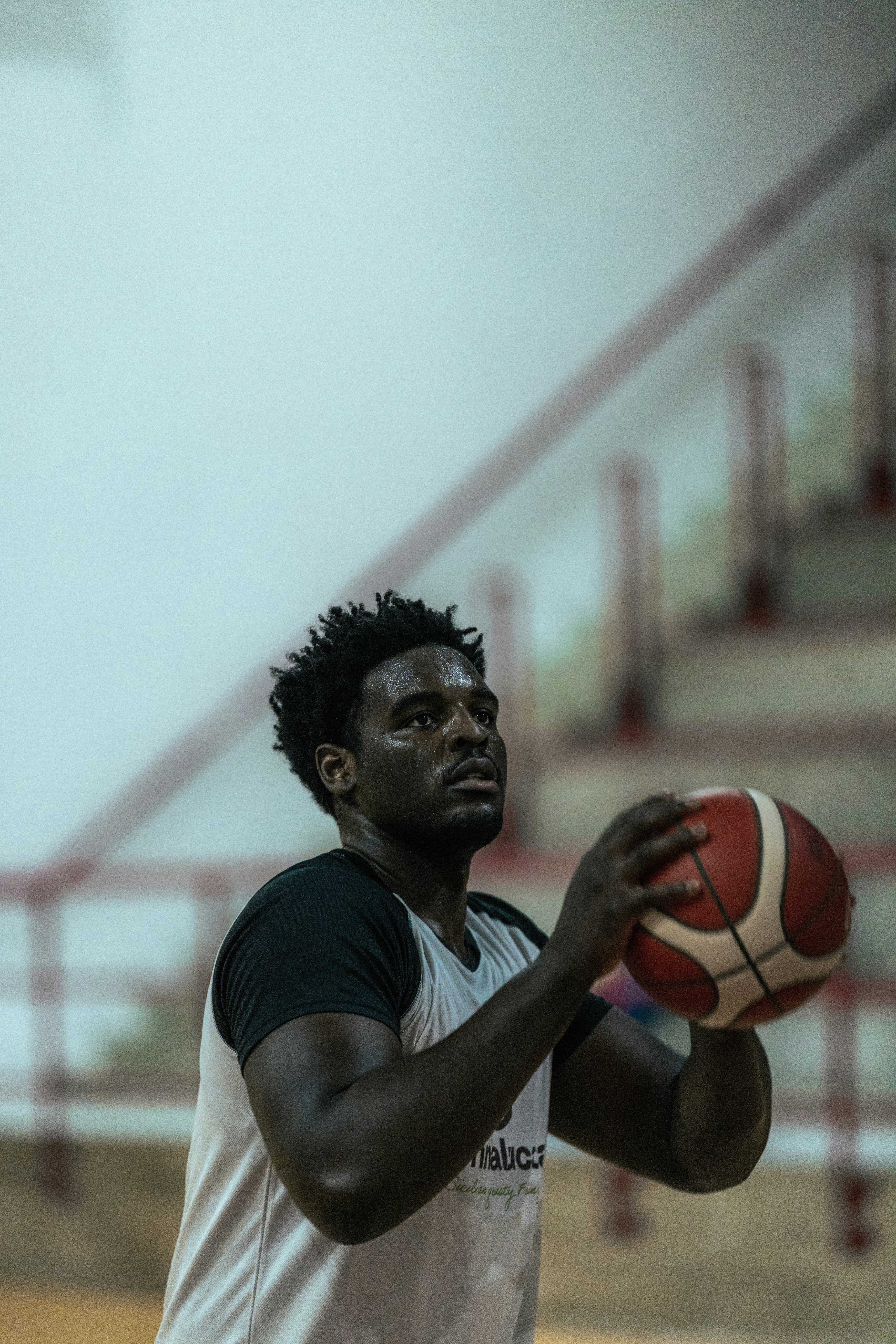 A basketball player holding a ball indoors.