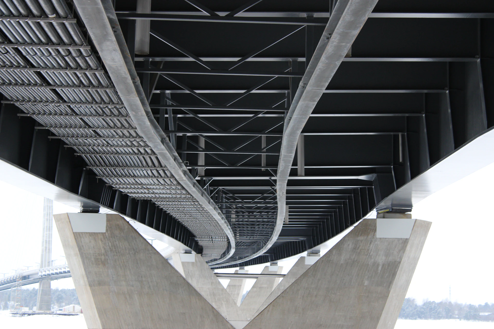 Underside of a modern bridge structure with concrete supports.