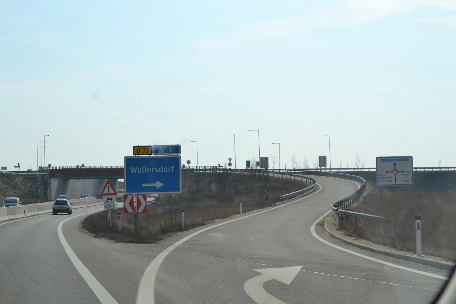 Austrian motorway interchange with blue direction signs and moving cars