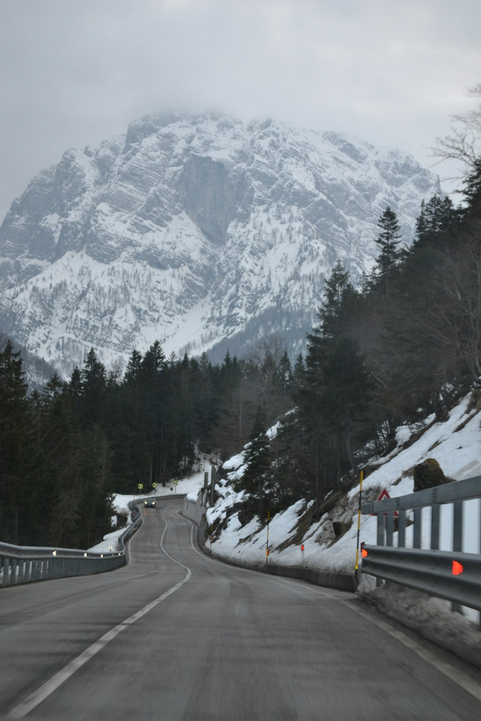 A winding alpine road through snow-covered mountains on the drive from Geneva toward Megève