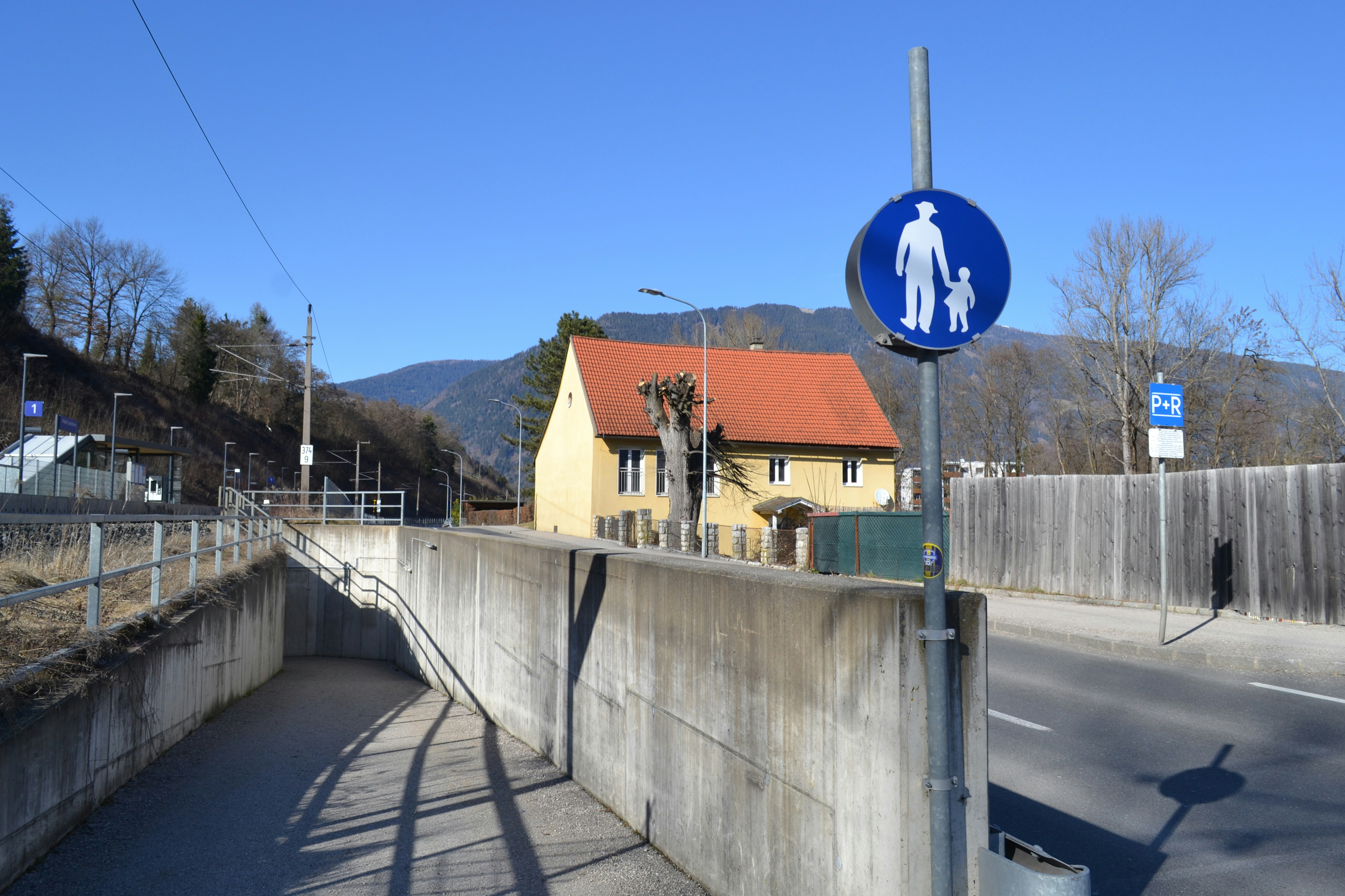 Pedestrian crossing sign near a tunnel entrance.