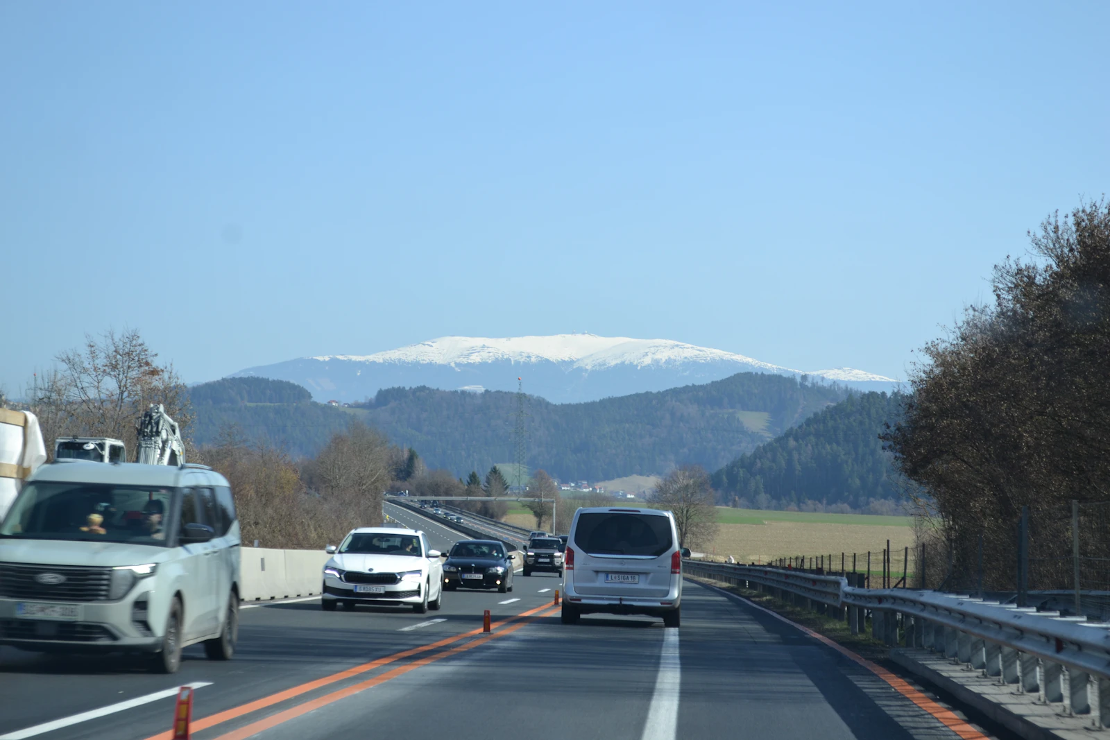 Traffic moving toward snow-capped mountains on an Austrian motorway