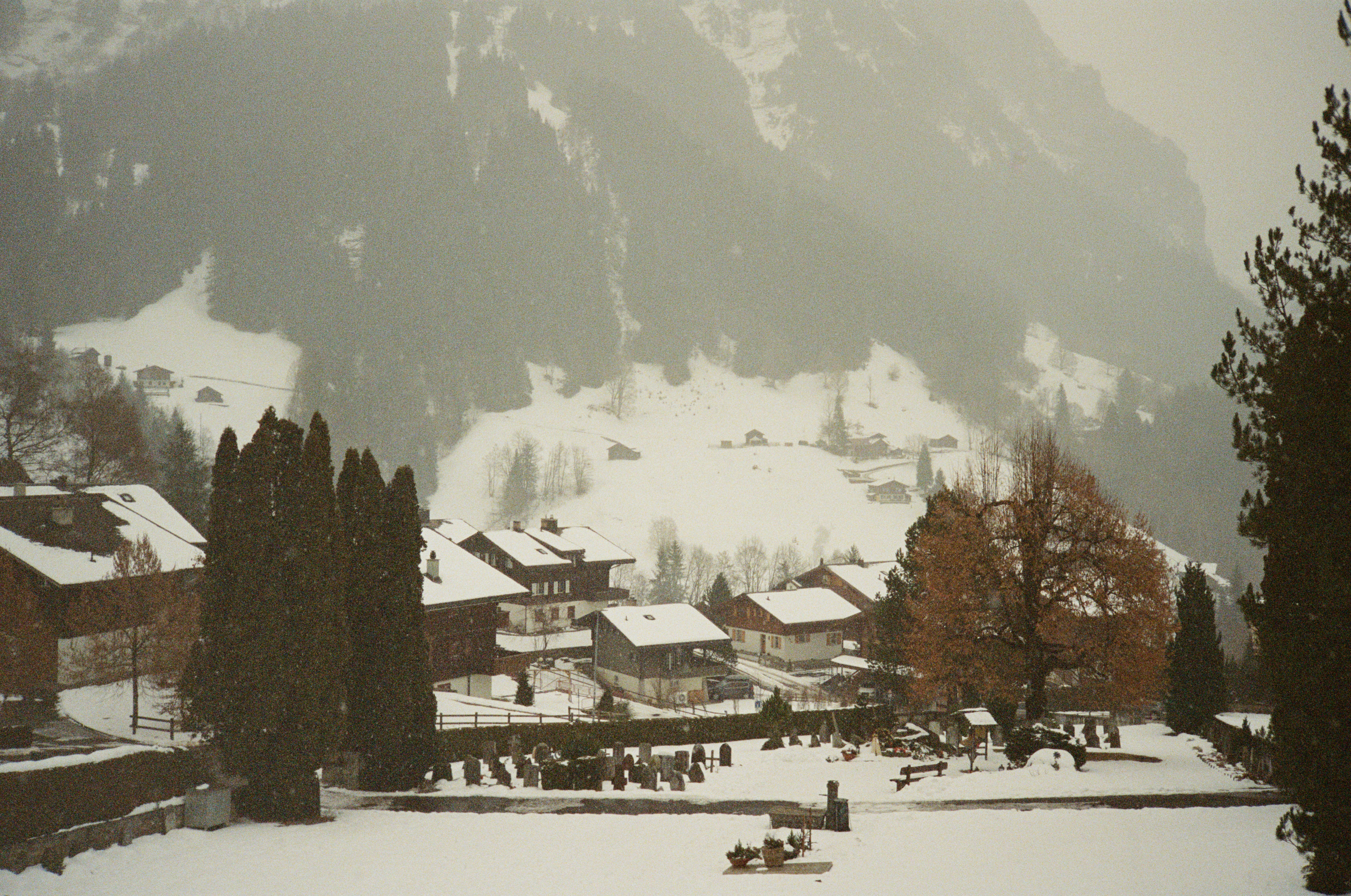 Snowy village nestled at the base of a mountain.