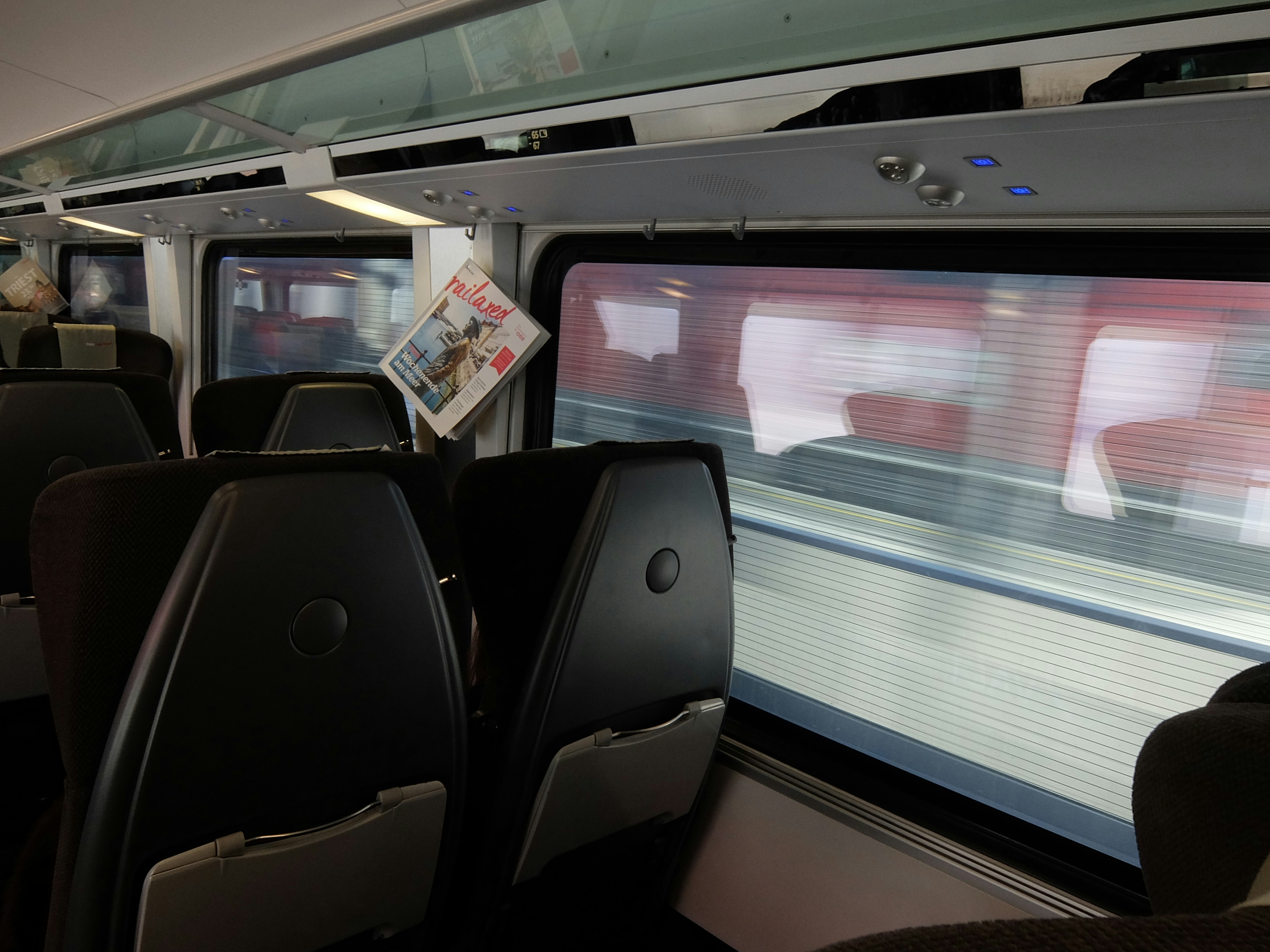 Kursi kereta kosong dengan pemandangan pemandangan yang lewat