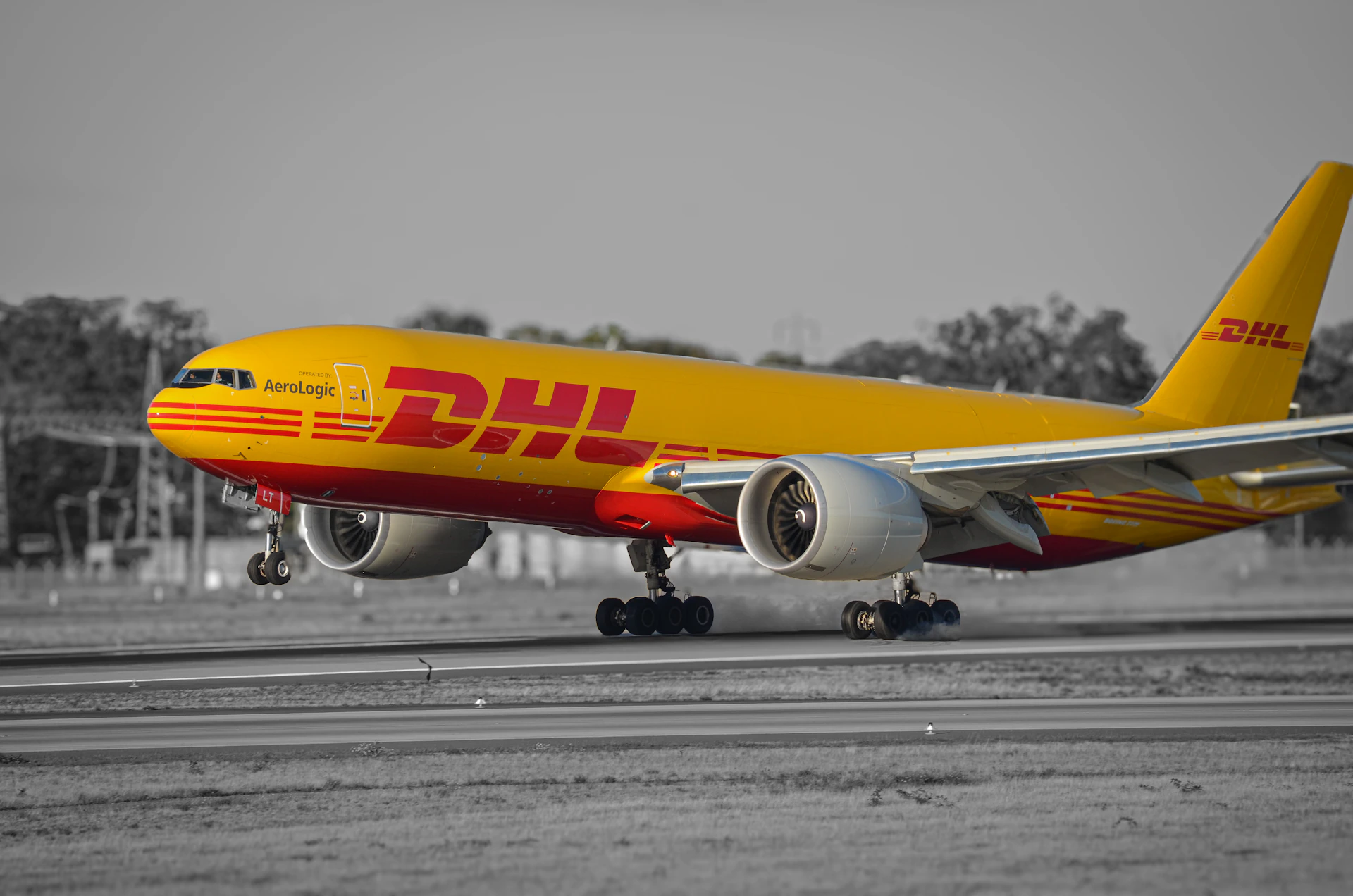 A dhl airplane lands on a runway.