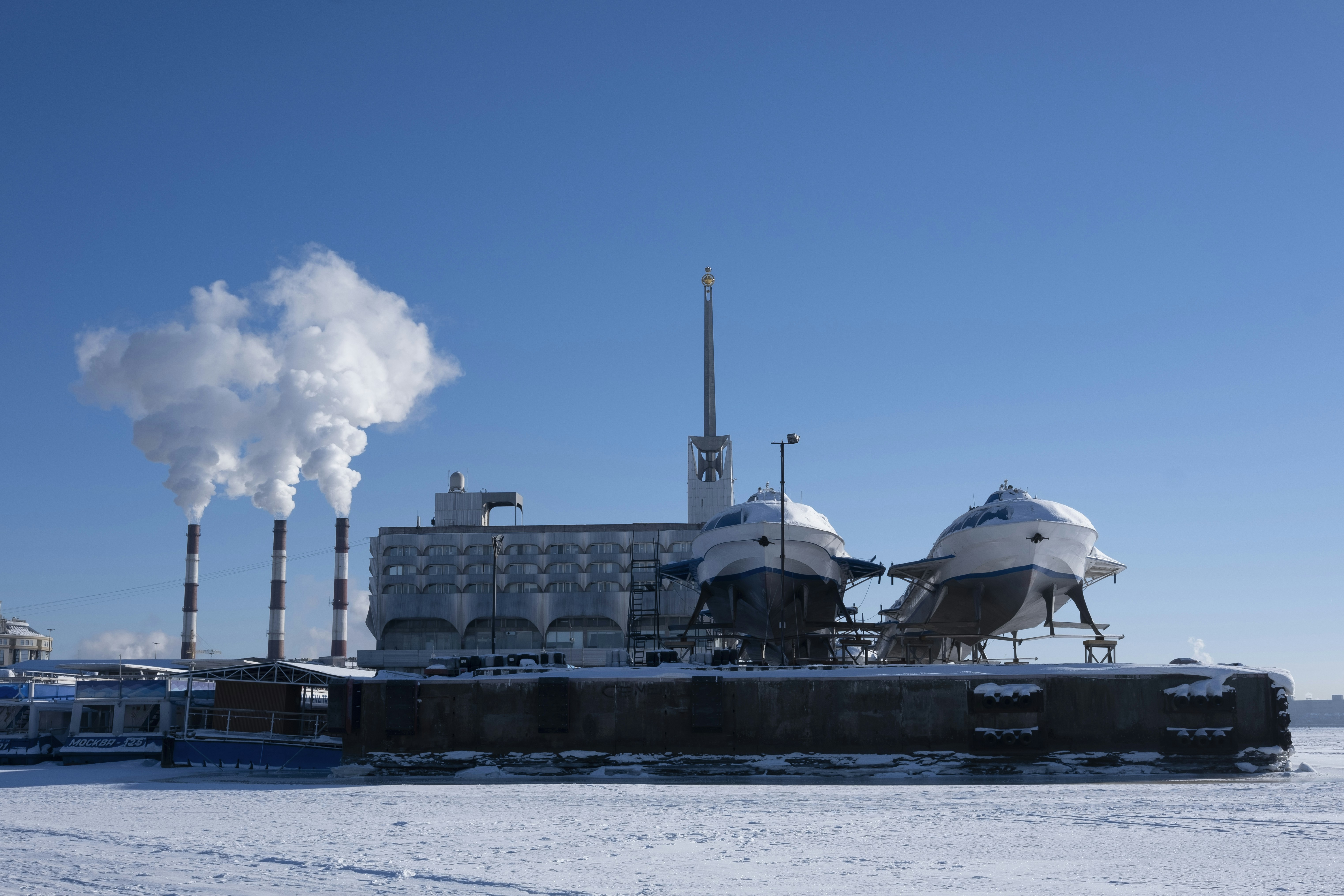 Boats on dry dock with industrial building and smoke stacks
