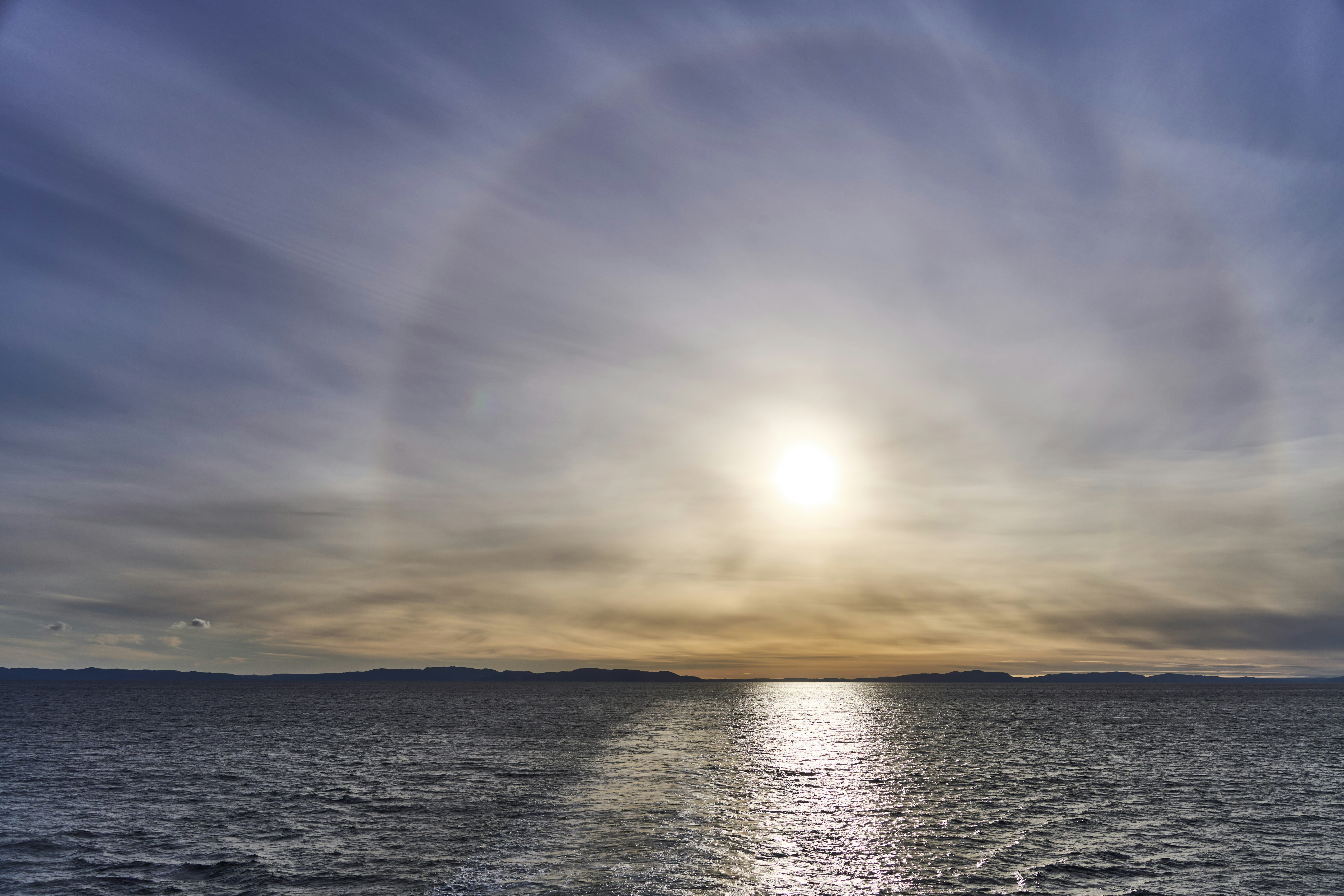 Sun halo over the ocean at sunset