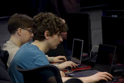Two young men focused on computer screens