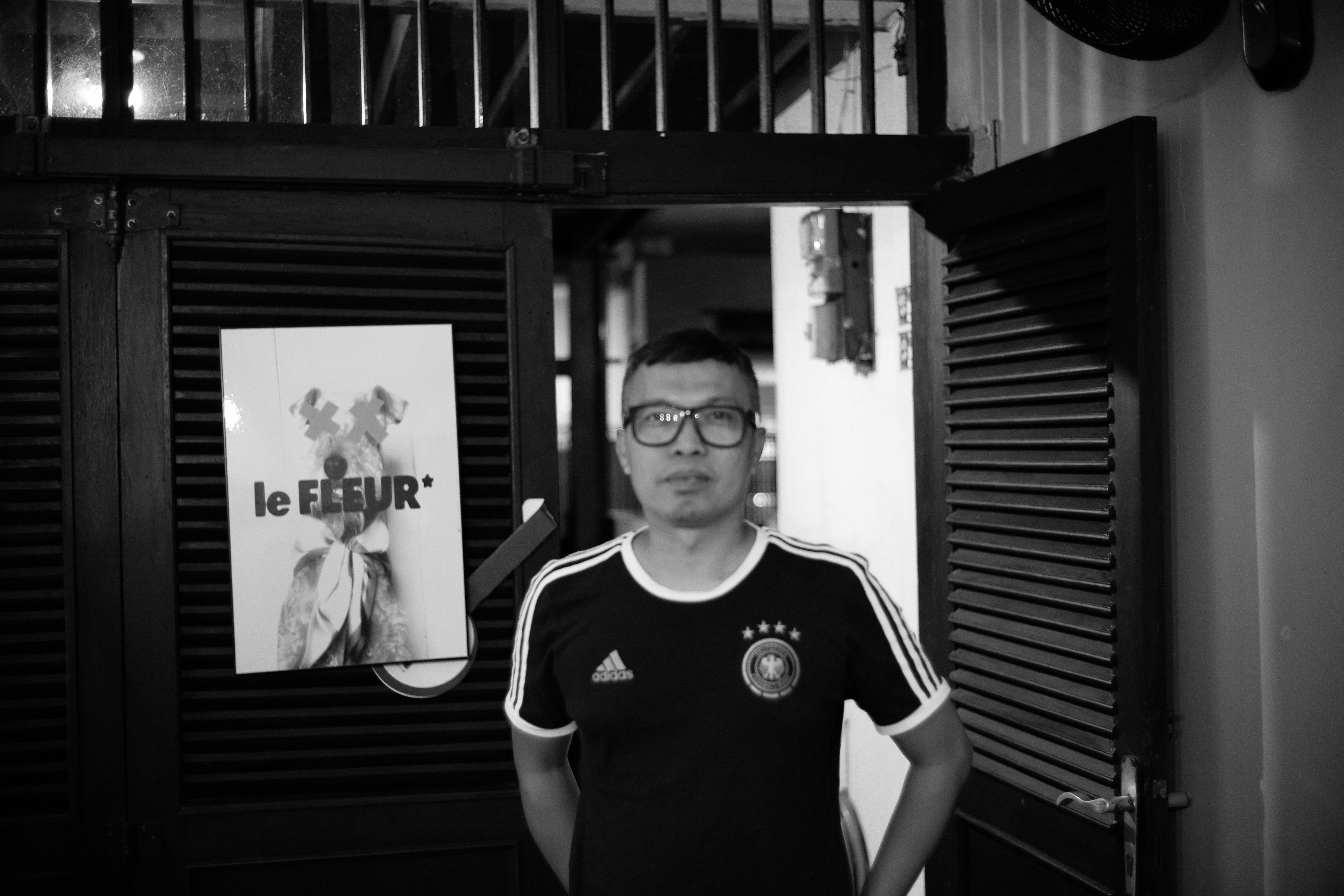 Homem com camisa de futebol parado na porta