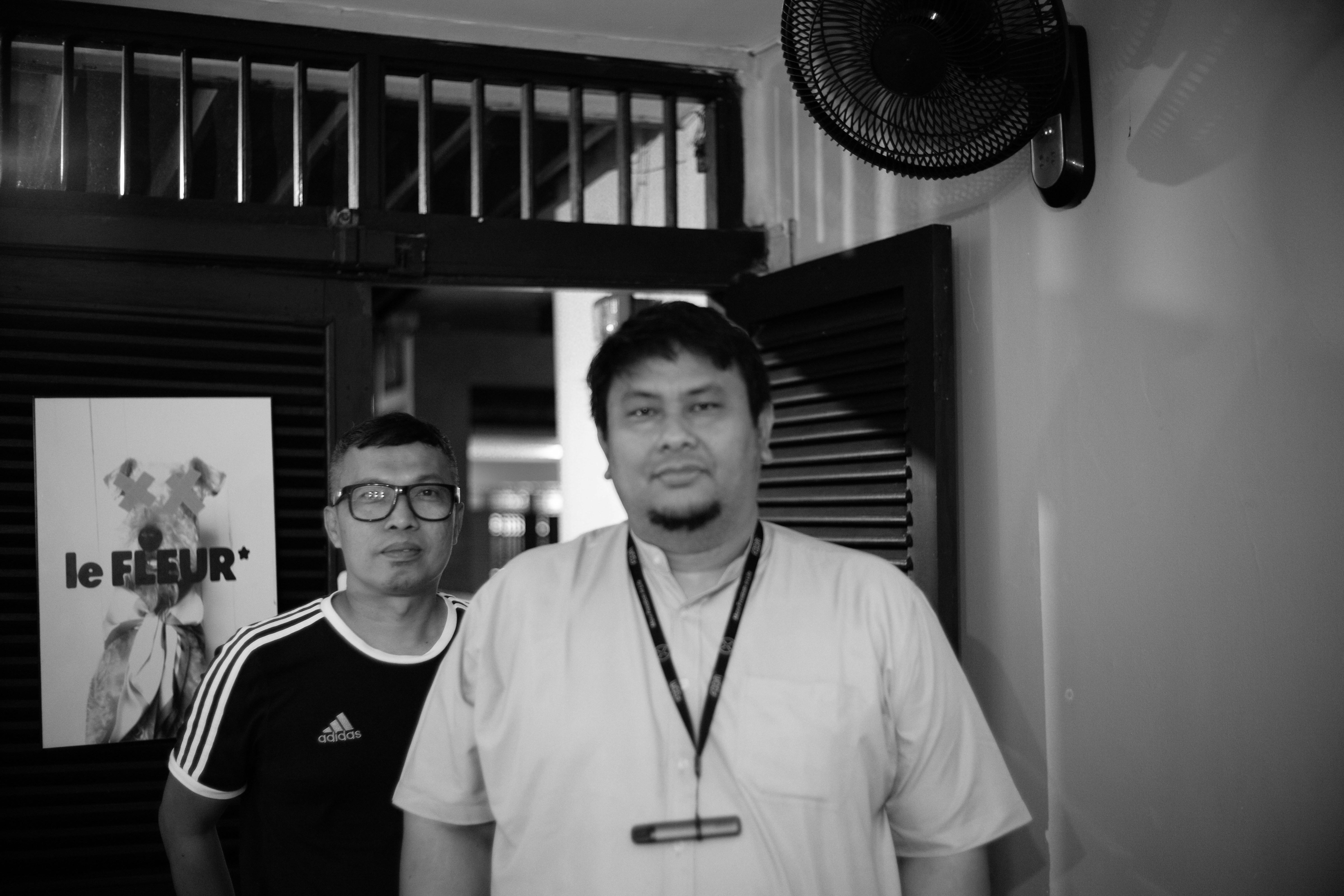 Dois homens em pé juntos dentro de casa