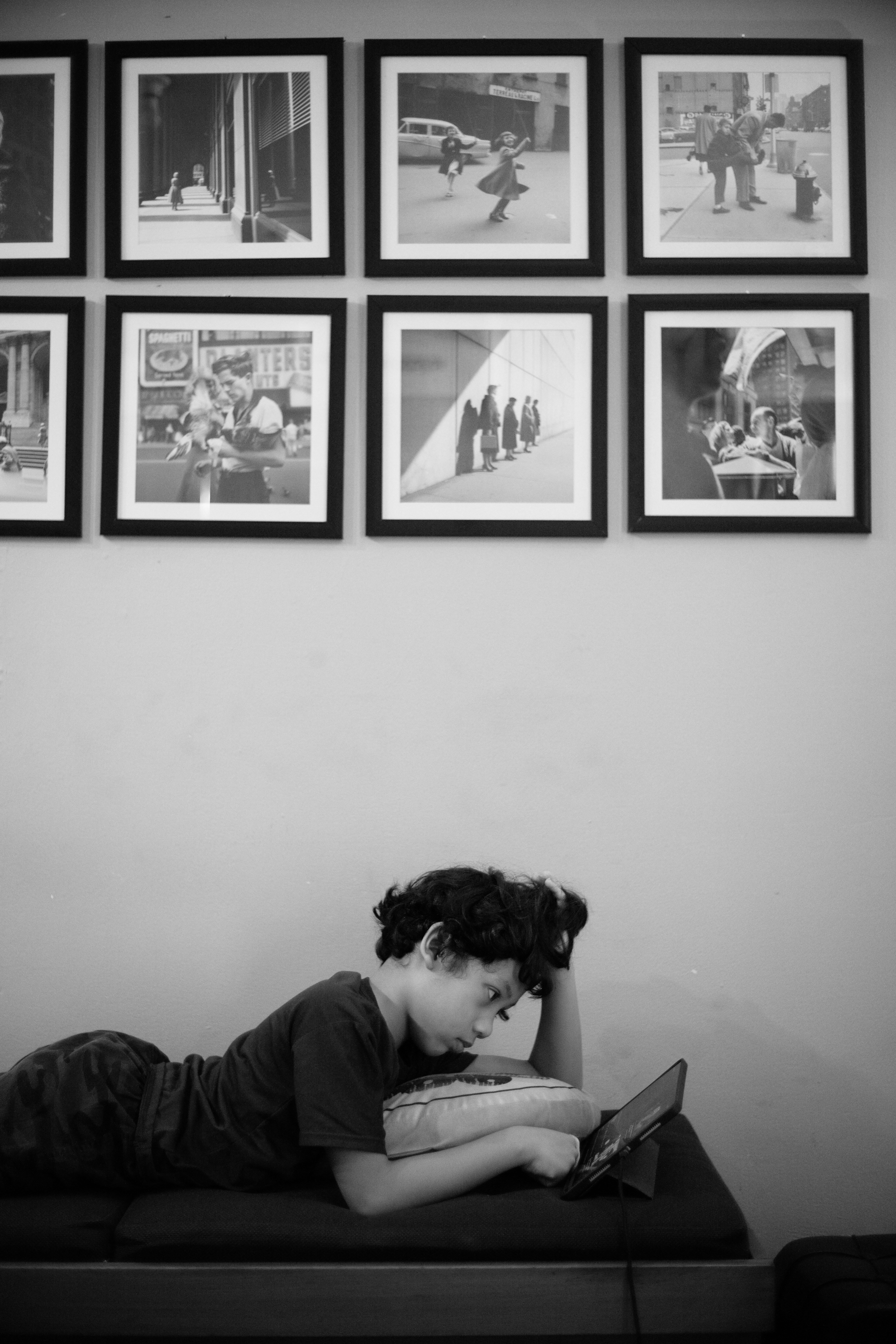 Menino deitado, olhando para um tablet e usando um tablet.