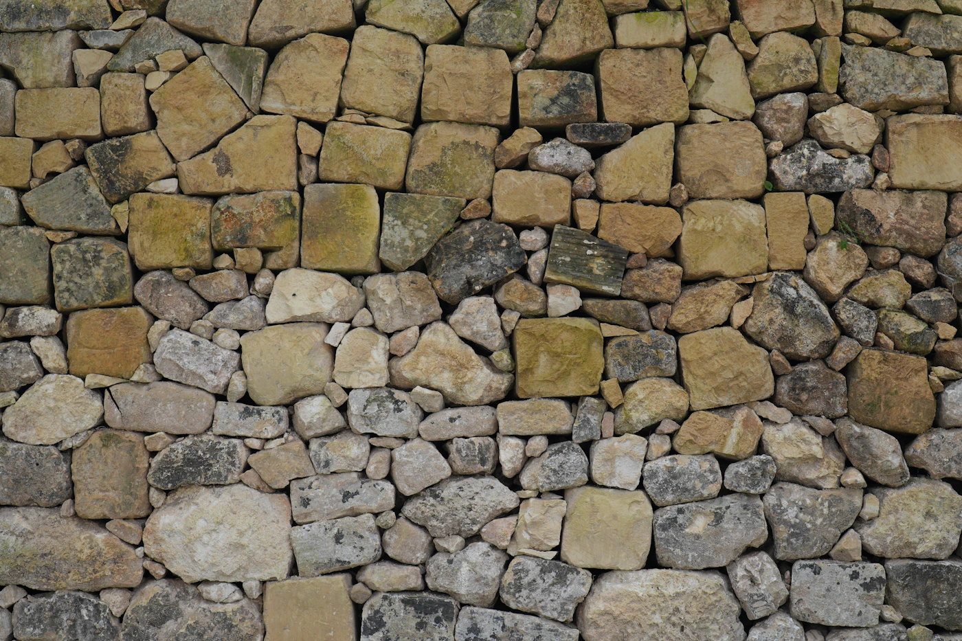 Mur restauré en pierres dorées du Beaujolais — joints chaux ferrée