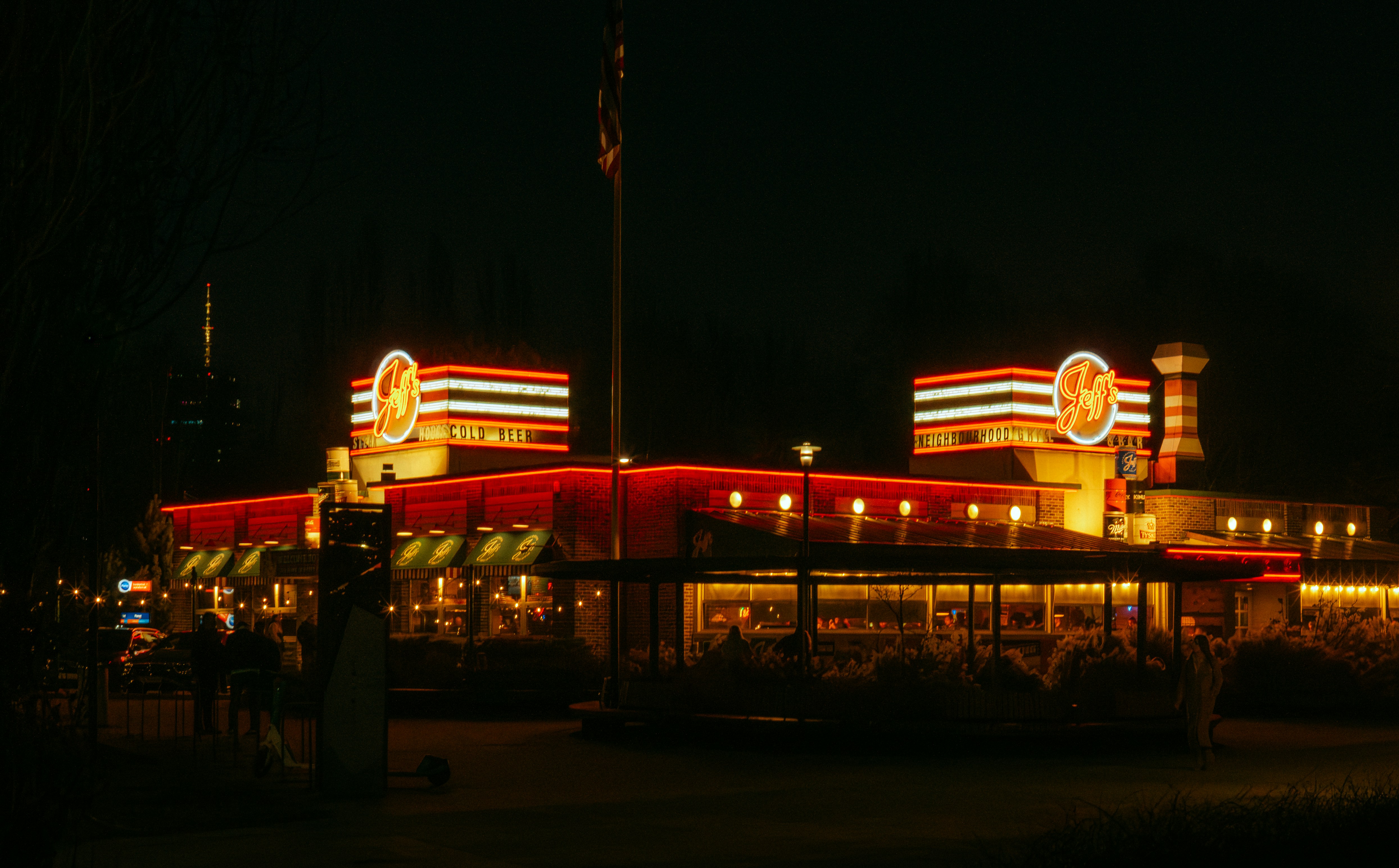 A brightly lit diner at night with neon signs.
