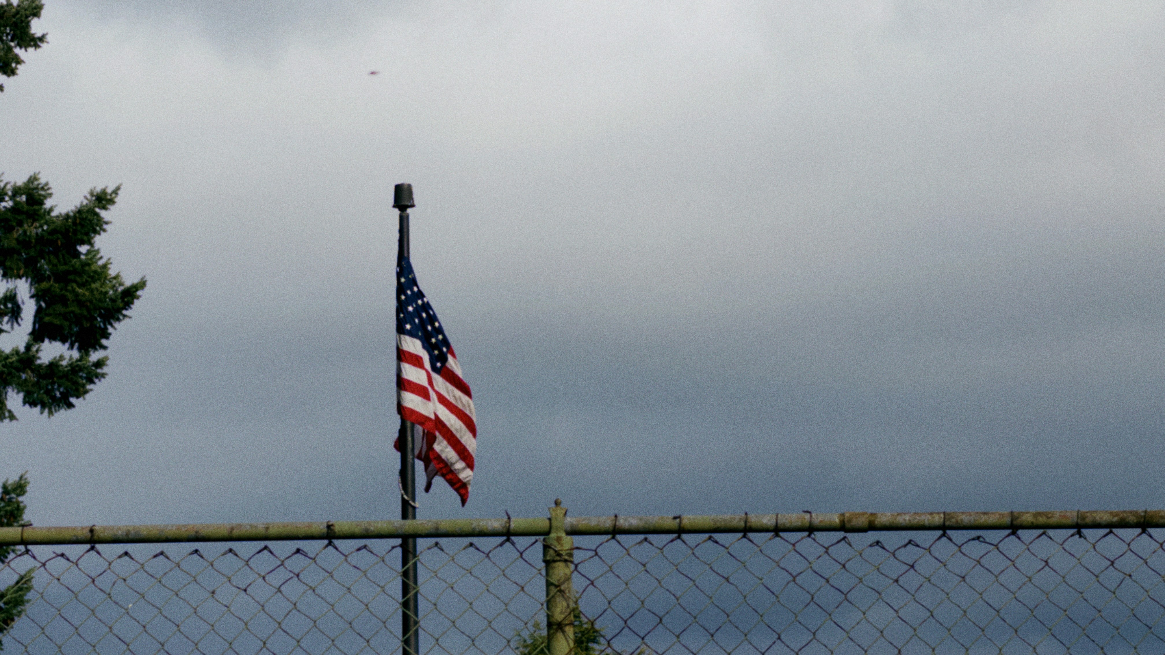 American flag on a pole under cloudy sky