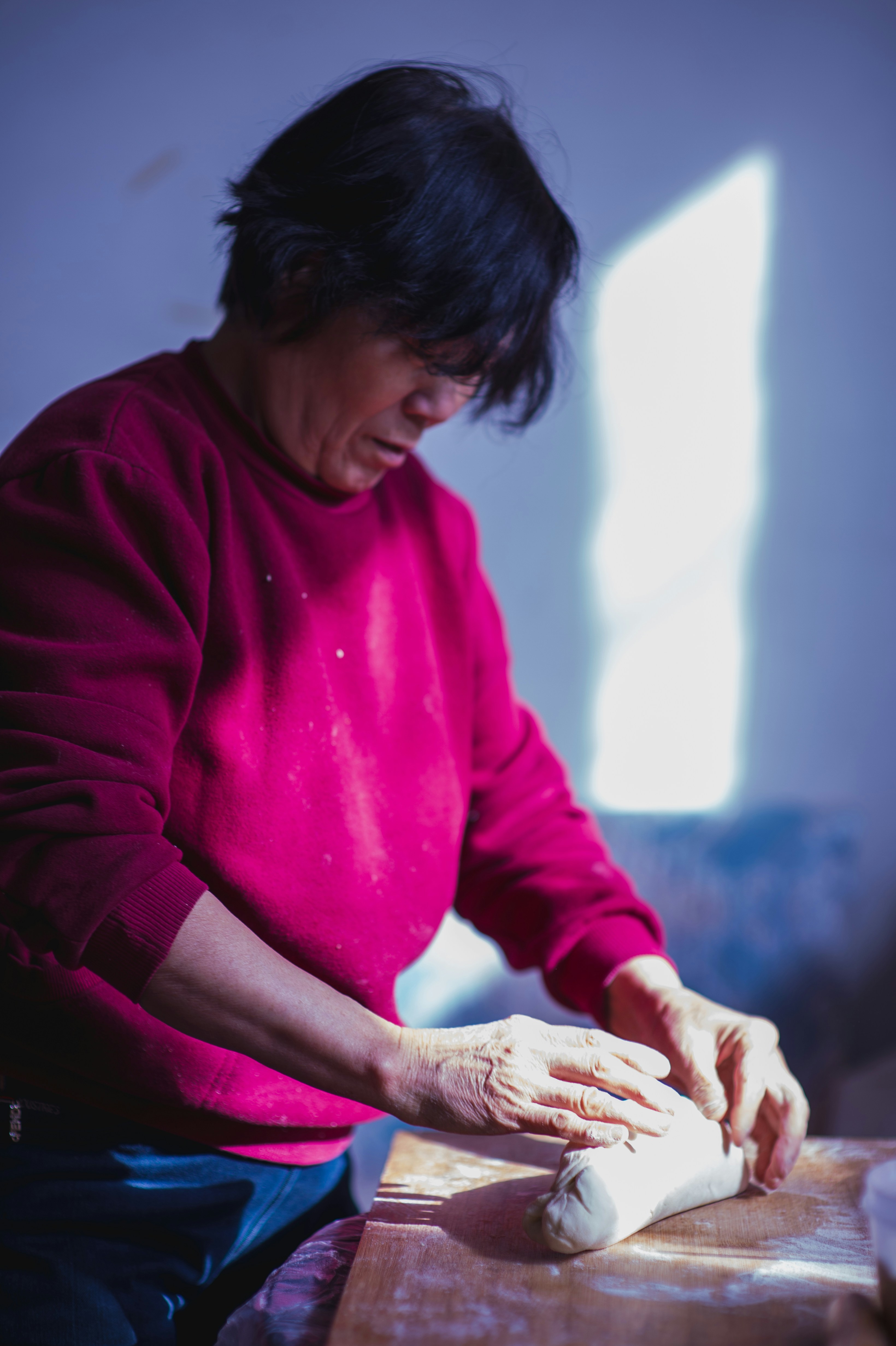 Woman shaping clay on a wooden table