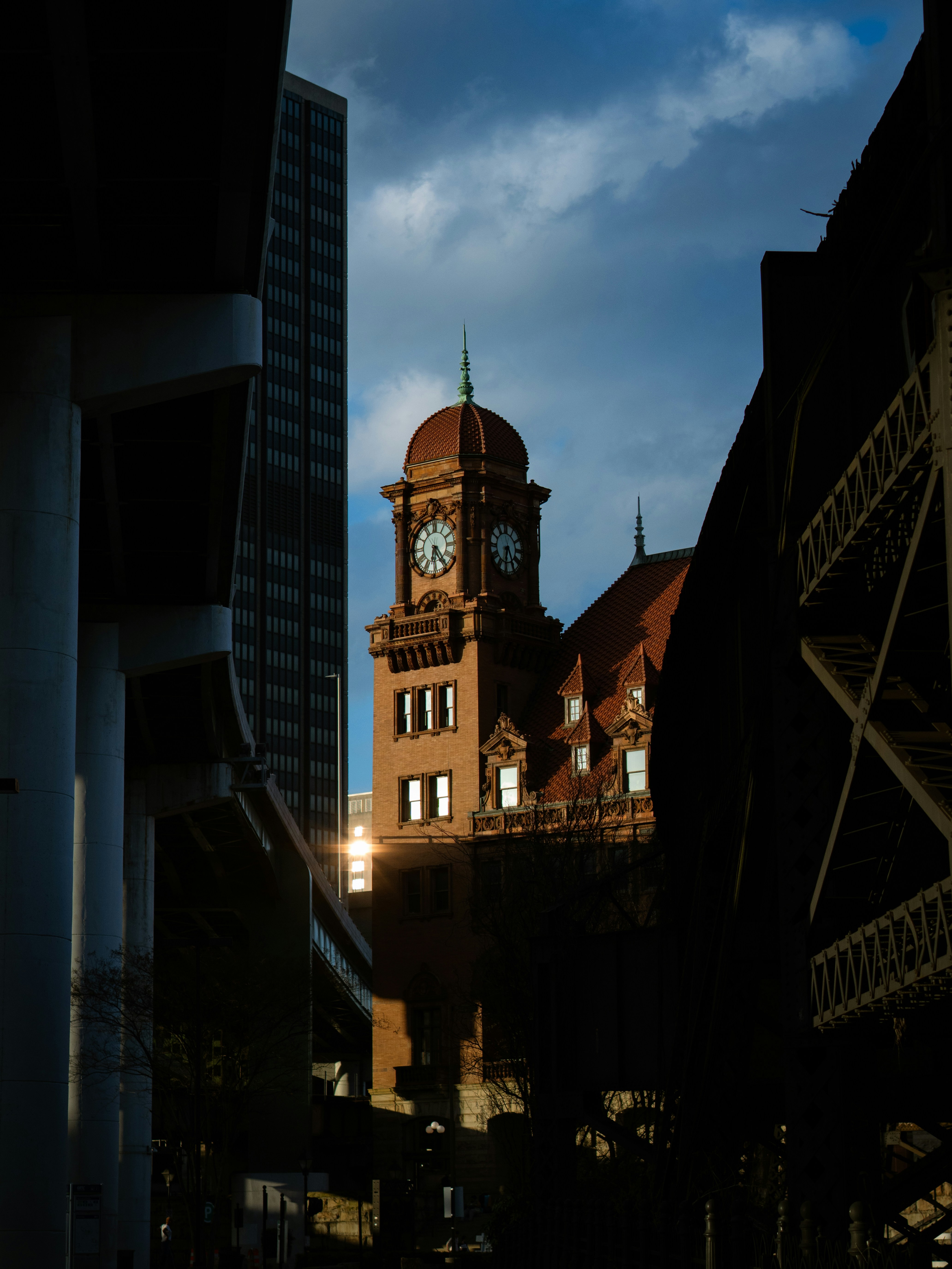 Historic clock tower building between modern structures
